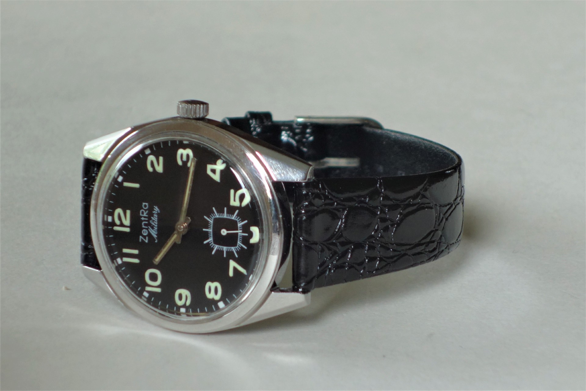 Schwarze Armbanduhr mit schwarzem Zifferblatt und schwarzem Armband.