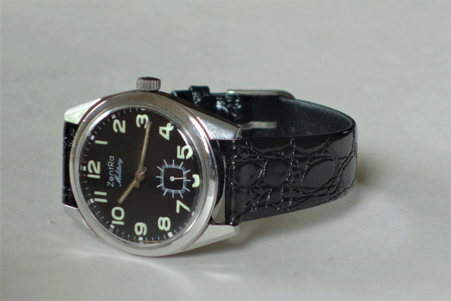 Schwarze Armbanduhr mit schwarzem Zifferblatt und schwarzem Armband.