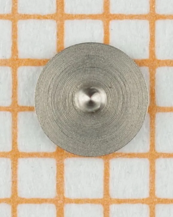 Rundes Aufzugsrad aus Metall für Uhrwerke, mit konzentrischen Rillen auf der Oberfläche.