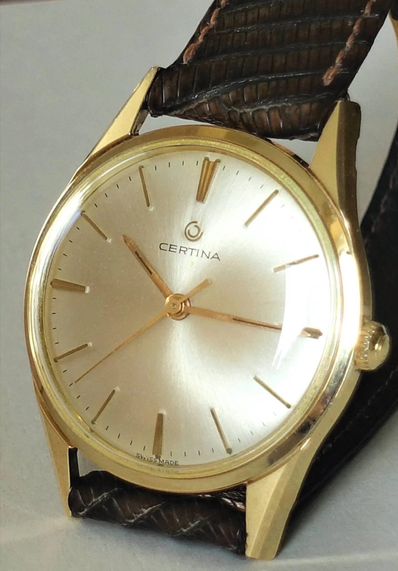 Certina Armbanduhr goldfarben Goldfarbene Certina Armbanduhr mit hellem Zifferblatt und braunem Armband.