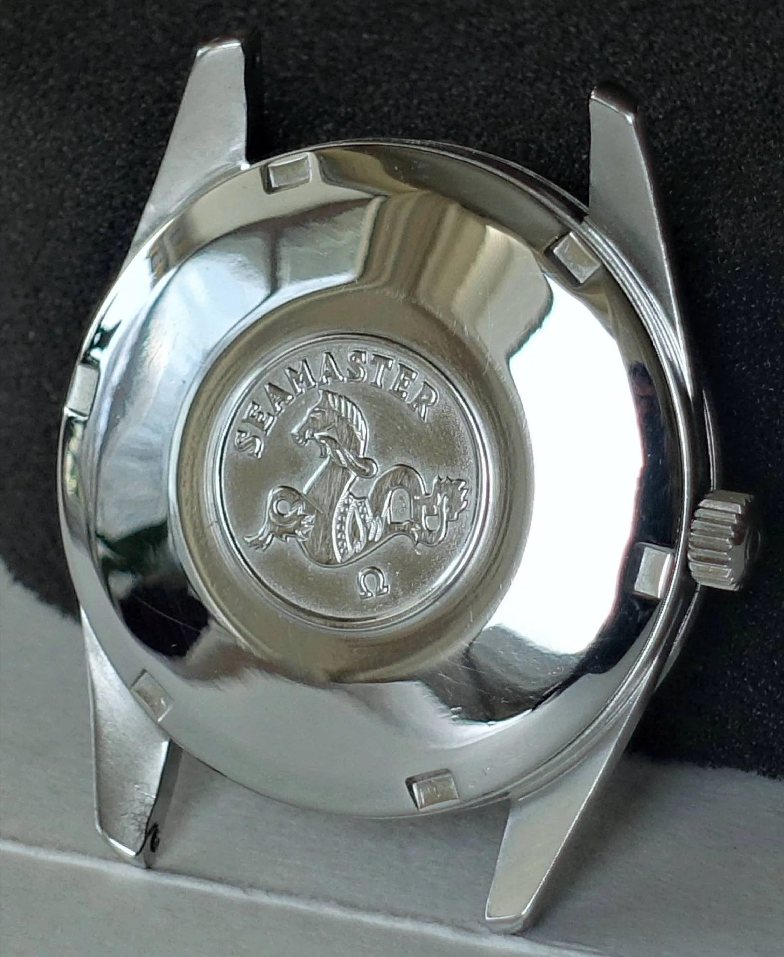 Gehäuse silberfarben Seamaster Silberfarbenes Uhrengehäuse mit graviertem Seamaster-Logo auf der Rückseite.