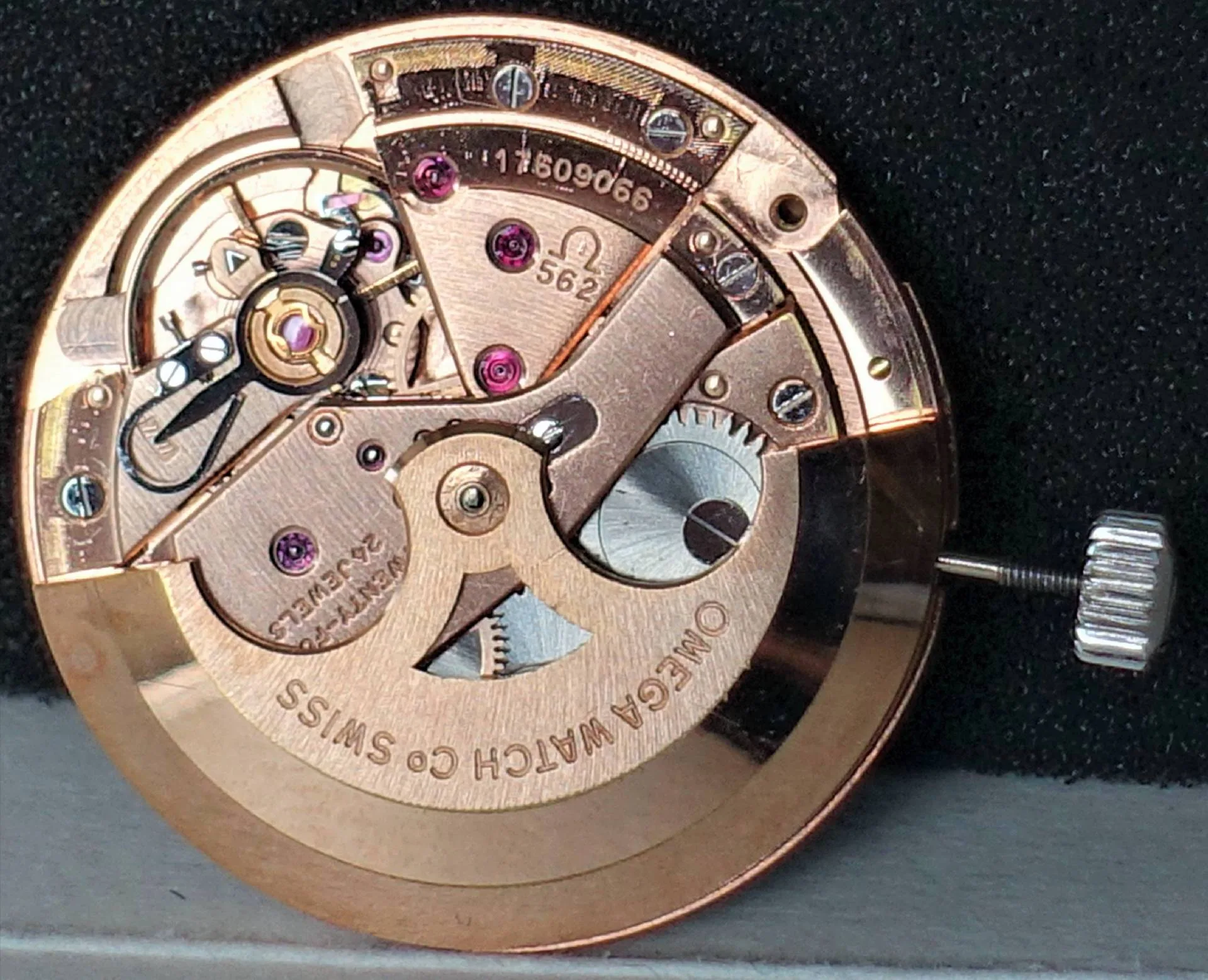Mechanisches Uhrwerk Omega 562 in goldfarbener Ausführung mit sichtbarer Krone und feinen Uhrwerkskomponenten.