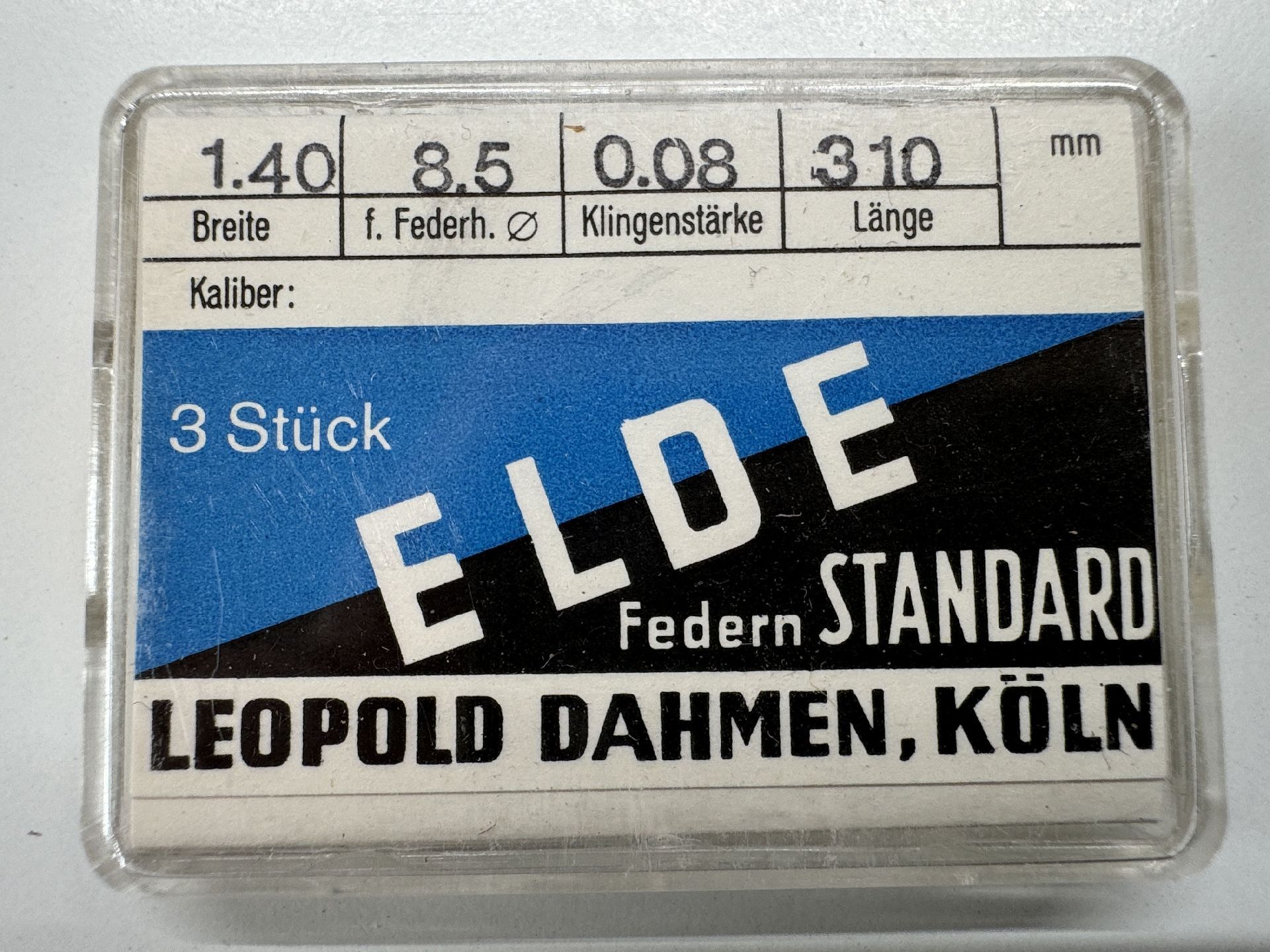 Verpackung mit drei Uhrmacher-Federn der Marke ELDE in einer transparenten Kunststoffbox.