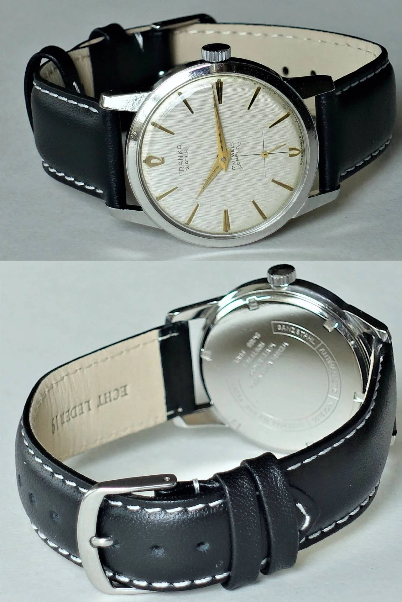 Silberfarbene Armbanduhr mit hellem Zifferblatt, goldfarbenen Indizes und schwarzem Lederarmband.