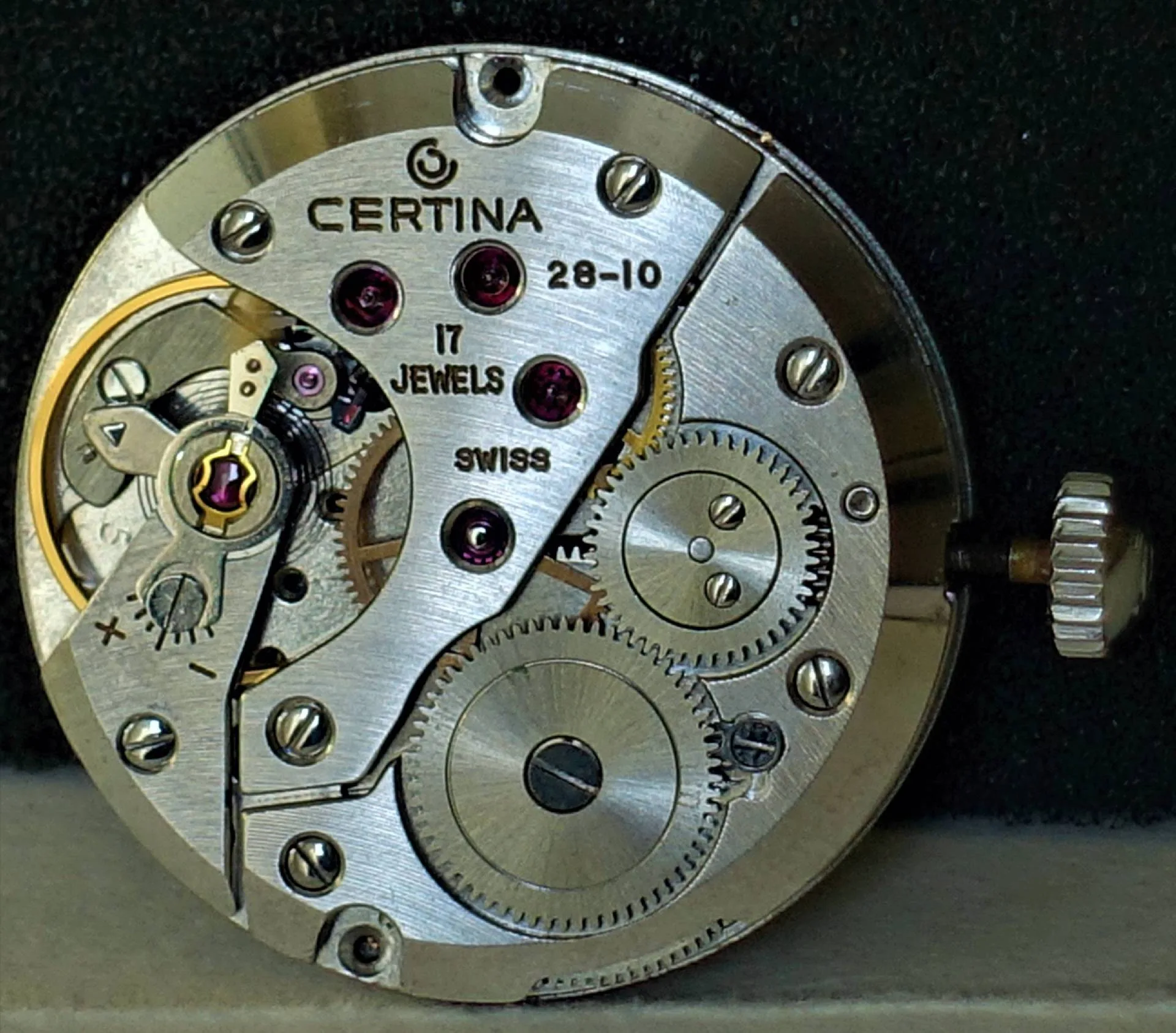Mechanisches Uhrwerk von Certina mit sichtbaren Zahnrädern und Aufzugswelle, silberfarben.