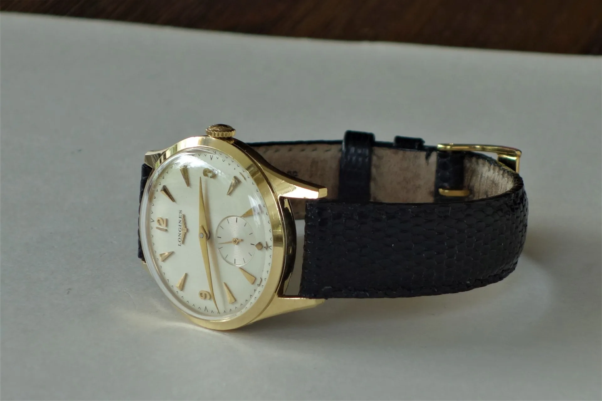 Armbanduhr goldfarben schwarz Goldfarbene Armbanduhr mit hellem Zifferblatt und schwarzem Armband.