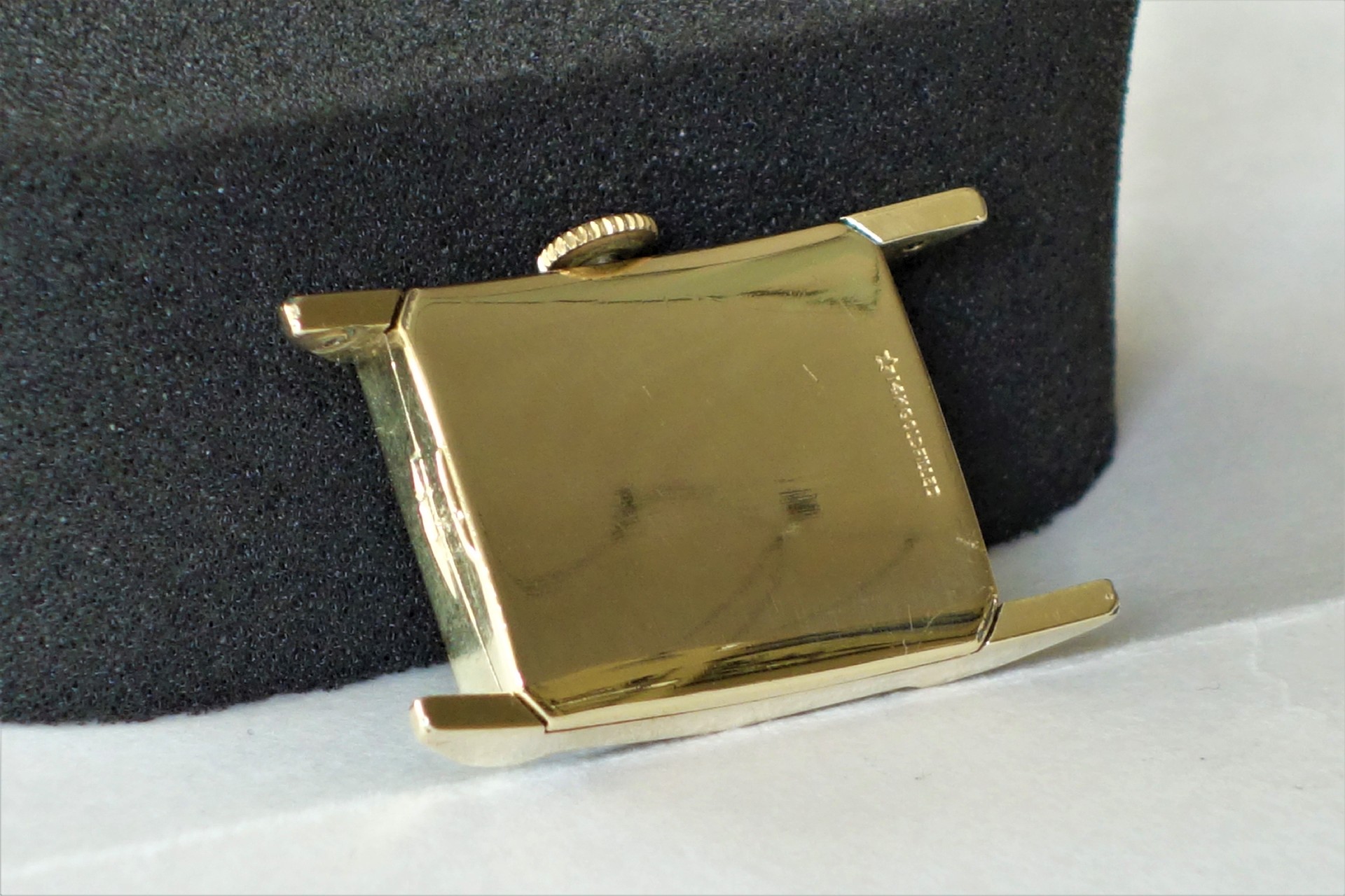 Rechteckiges Uhrengehäuse in goldfarbener Ausführung mit seitlicher Krone.