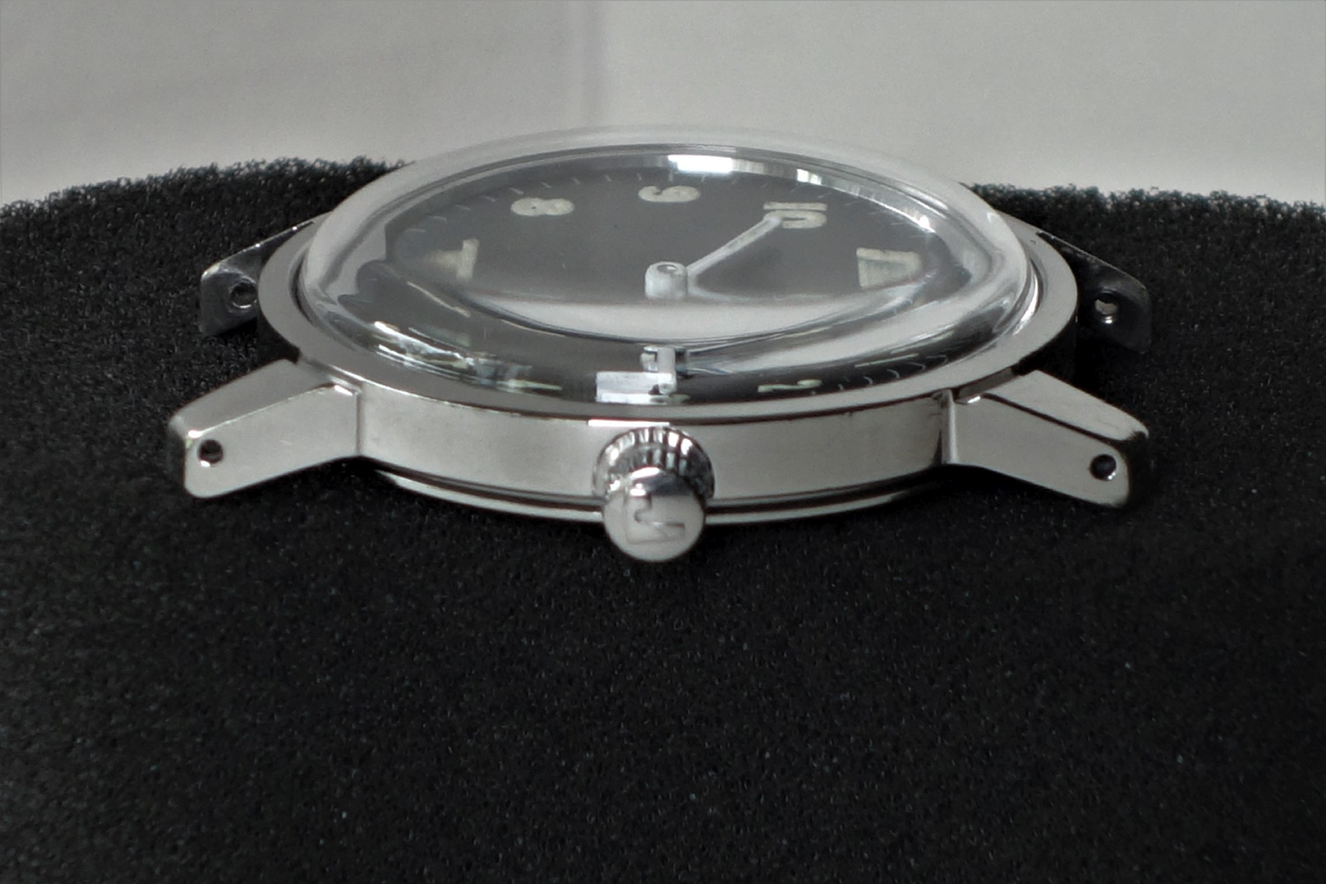 Silberfarbenes Uhrgehäuse mit Glas und Krone, ohne Armband.