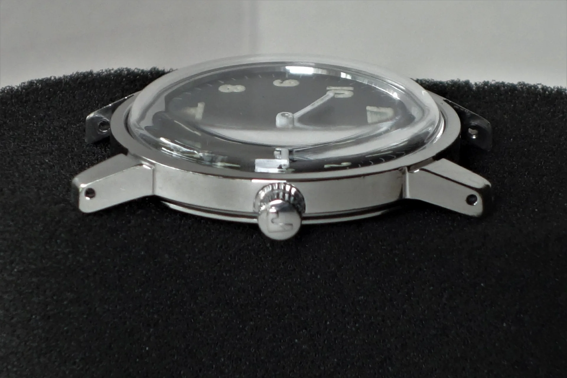 Silberfarbenes Uhrgehäuse mit Glas und Krone, ohne Armband.