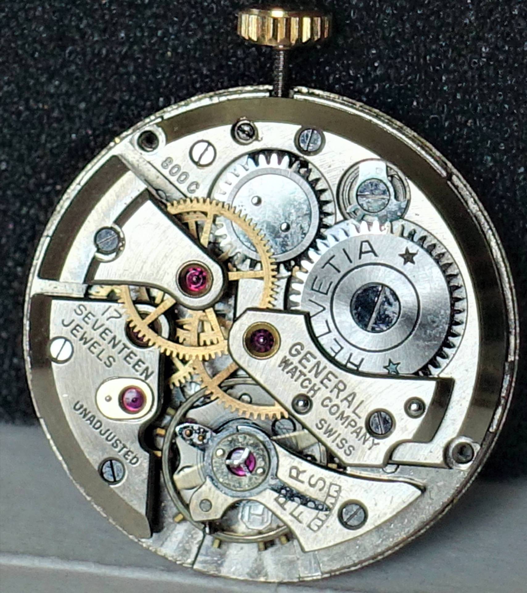 Mechanisches Uhrwerk mit sichtbaren Zahnrädern und Gravur "Helvetia" sowie "General Watch Company Swiss".