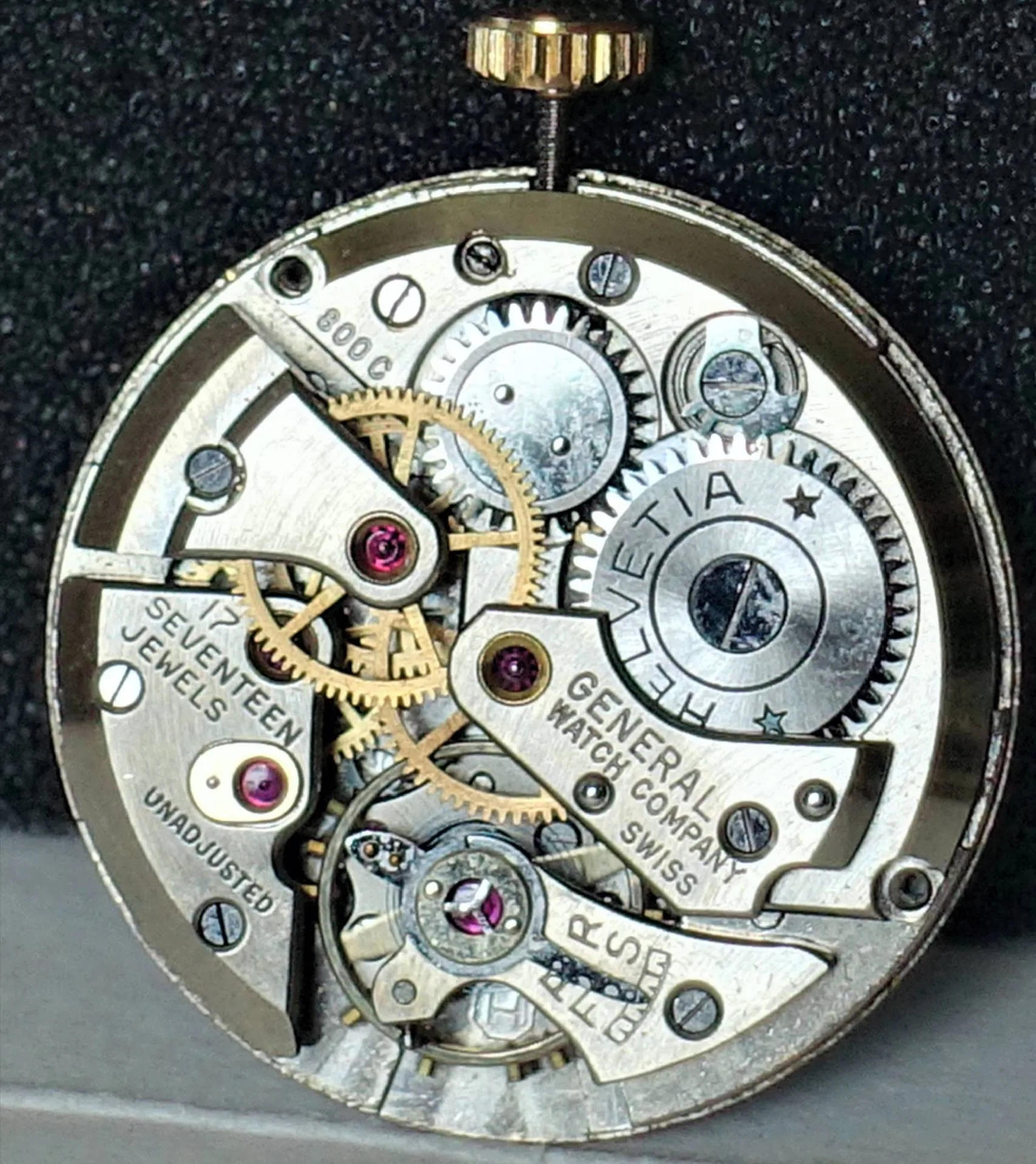 Mechanisches Uhrwerk mit sichtbaren Zahnrädern und Gravur "Helvetia" sowie "General Watch Company Swiss".