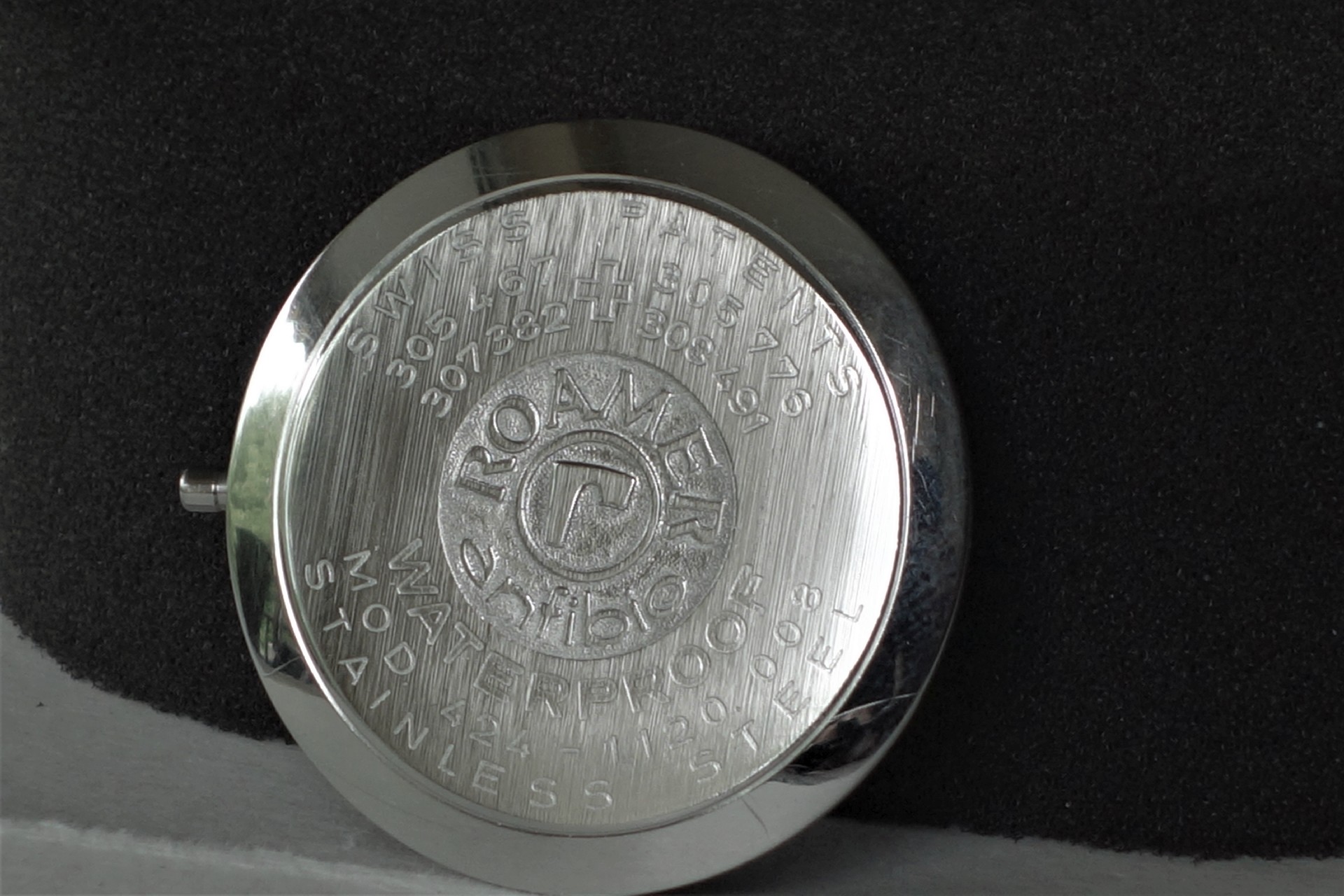 Silberfarbener Gehäuseboden mit eingraviertem Roamer-Logo und Schriftzug.