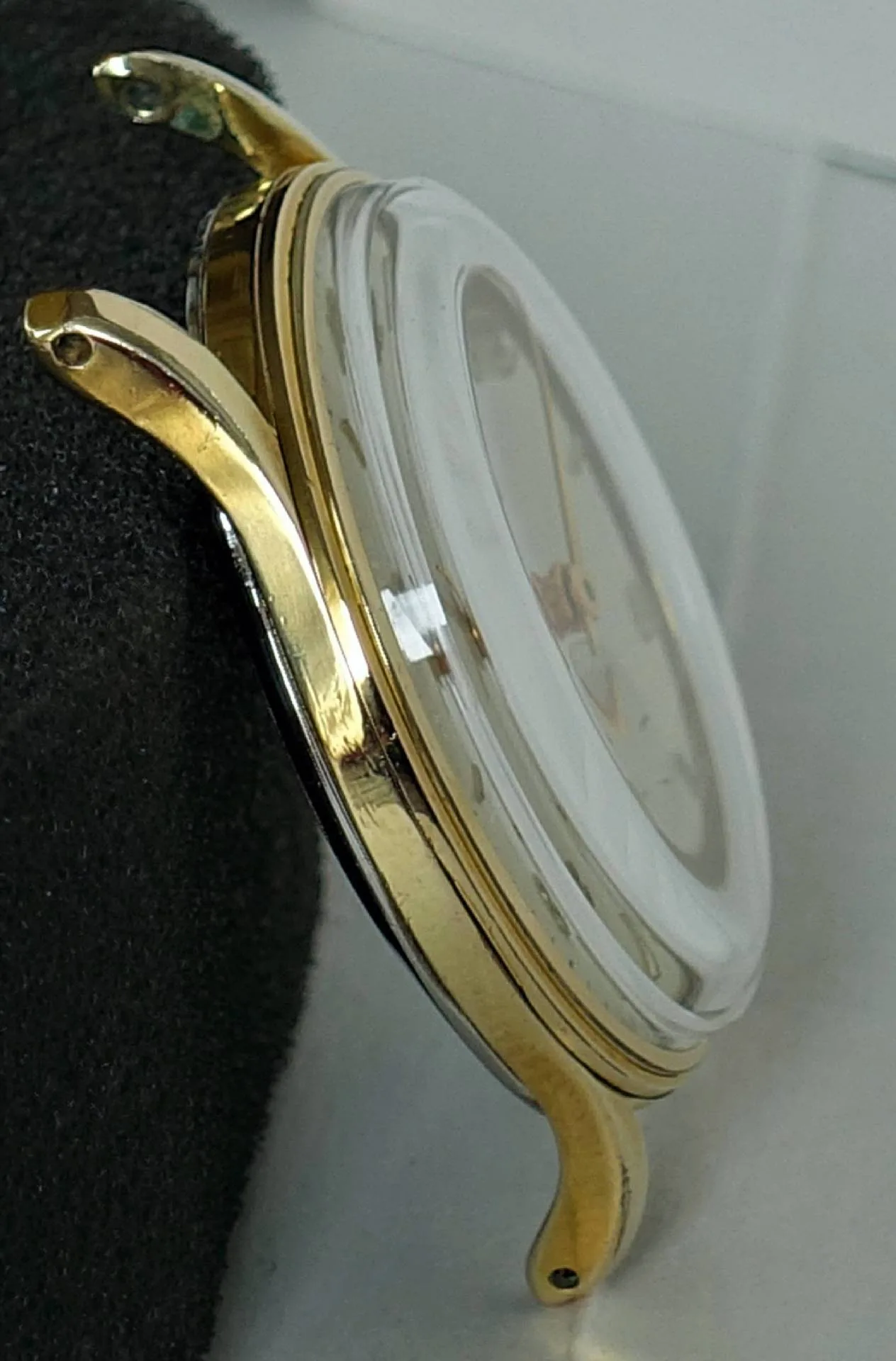 Uhrgehäuse goldfarben Goldfarbenes Uhrgehäuse mit montiertem Glas, ohne Armband und Krone.