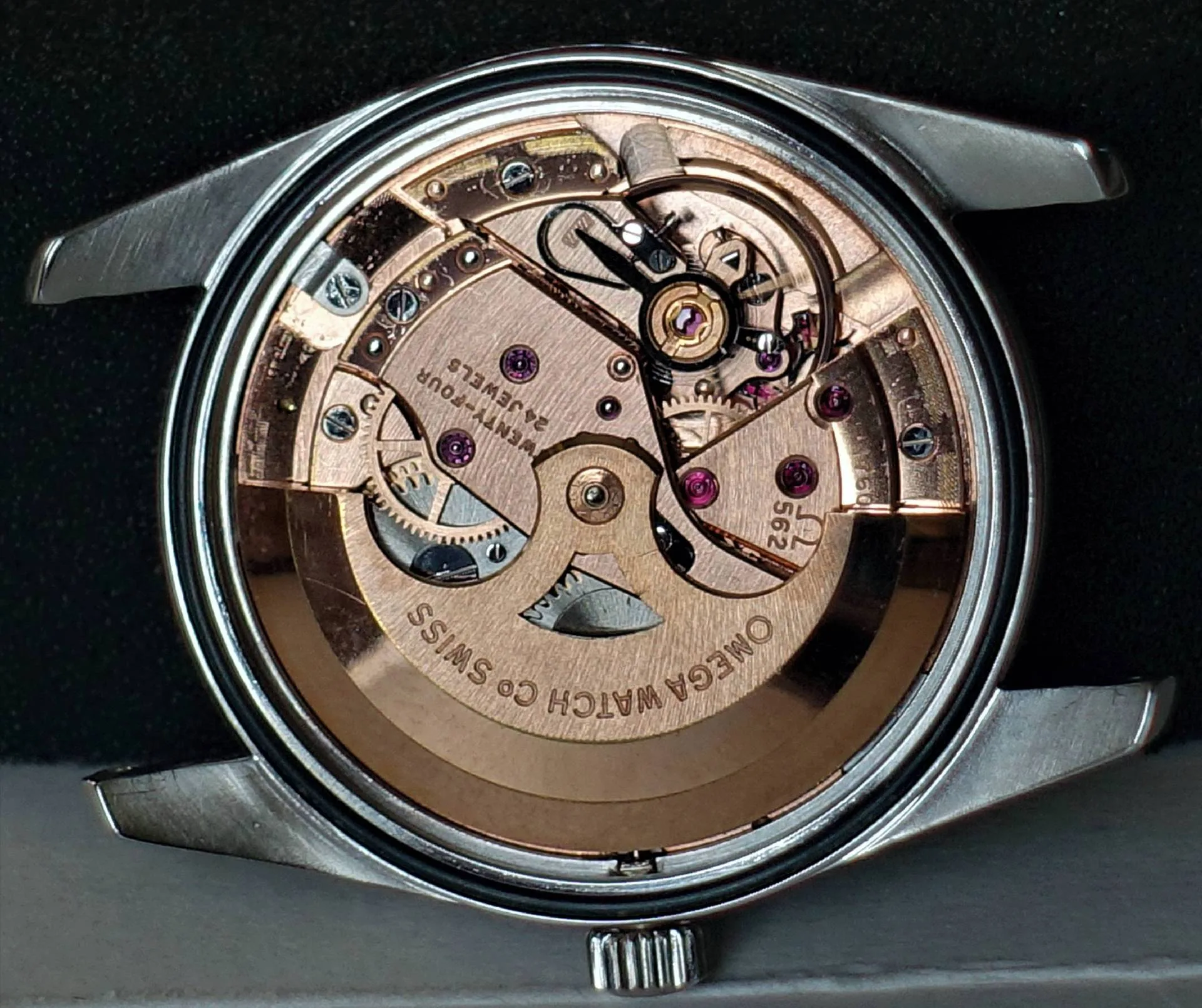 Uhrwerk Omega Kaliber 562 Mechanisches Uhrwerk in goldfarbener Ausführung mit sichtbaren Zahnrädern und Gravur "OMEGA WATCH CO SWISS".