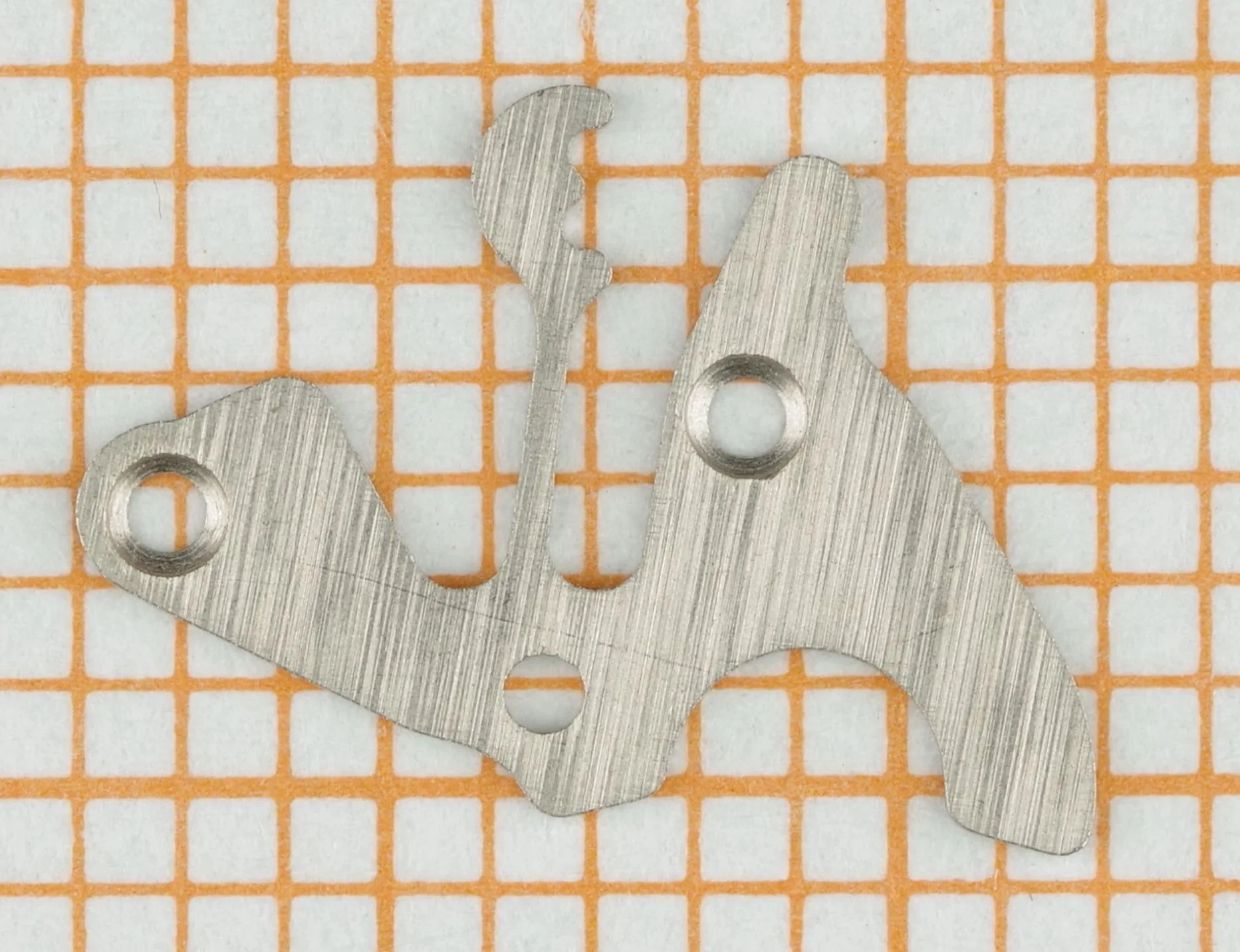 Uhrwerk Brückenteil Metall Flaches, silberfarbenes Brückenteil aus Metall für ein Uhrwerk.