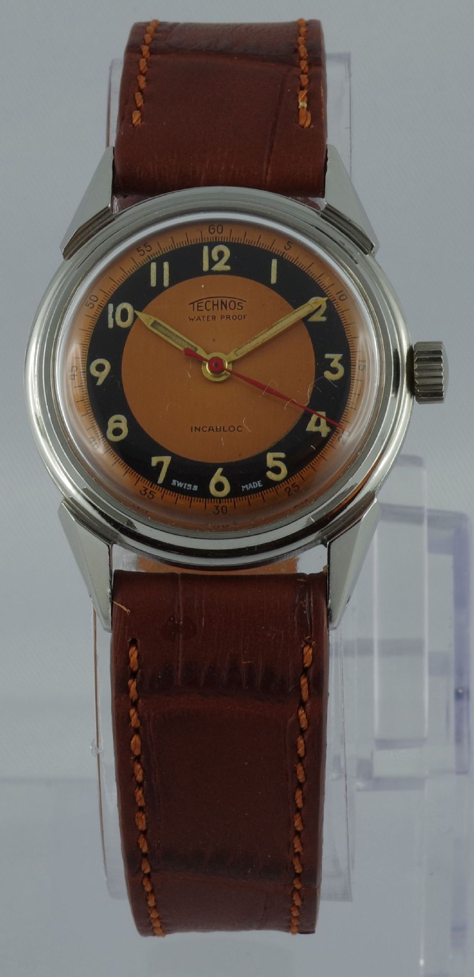Analoge Armbanduhr mit braunem Lederarmband und zweifarbigem Zifferblatt in Orange und Schwarz.