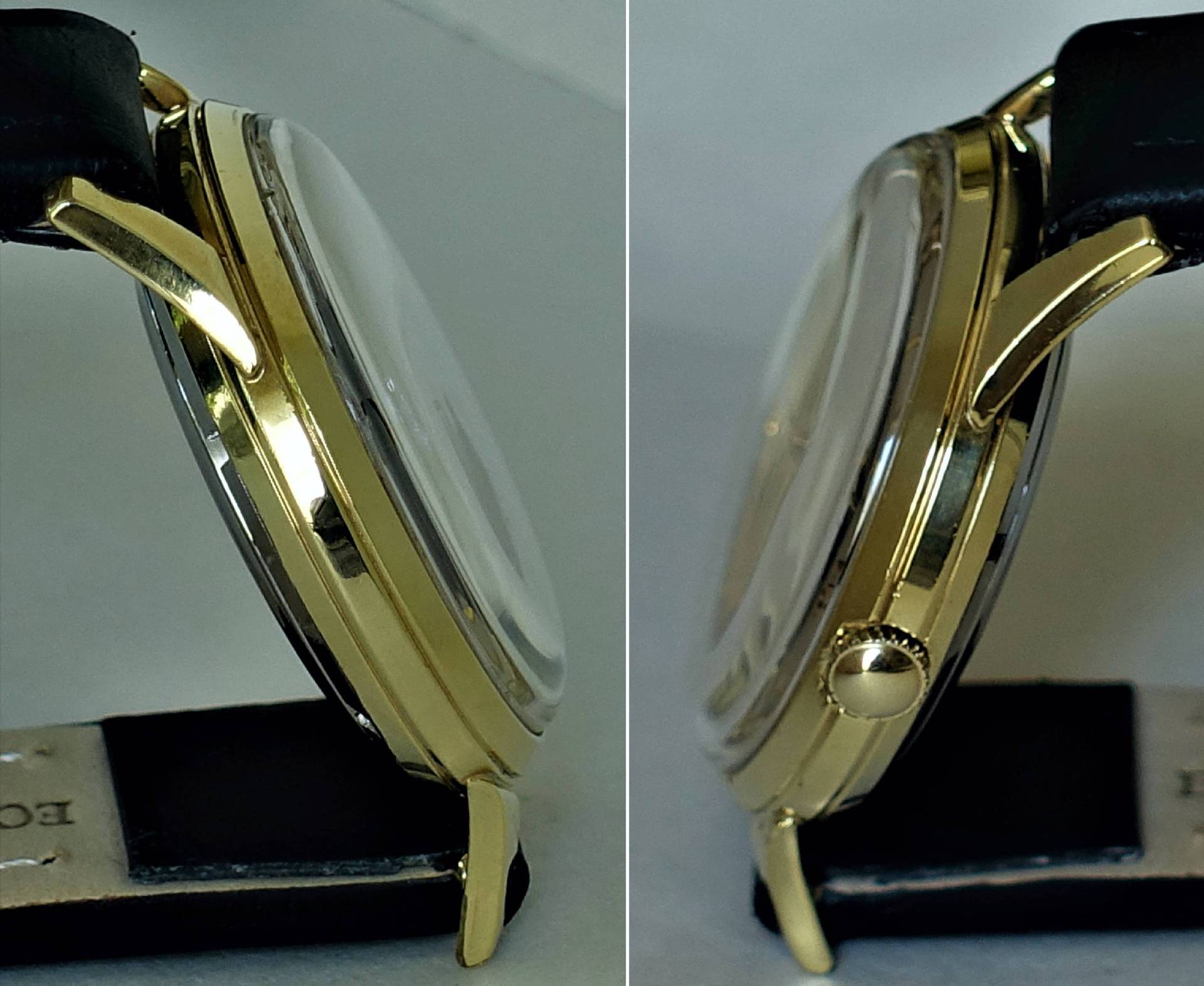 Rundes Uhrengehäuse in goldfarbener Optik mit seitlicher Krone und schwarzem Armband.