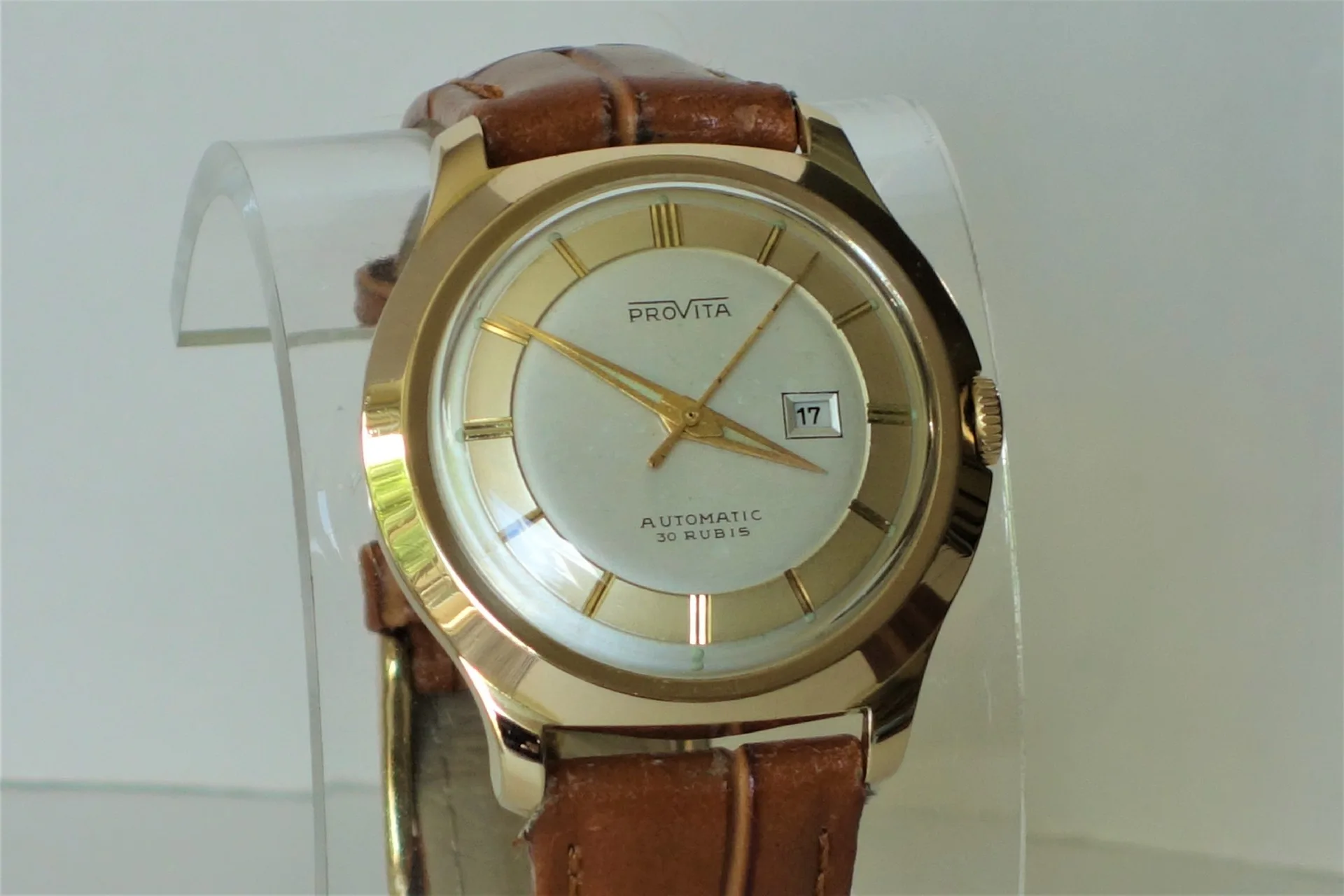 Automatik Armbanduhr goldfarben Goldfarbene Armbanduhr mit braunem Lederarmband und Datumsanzeige.