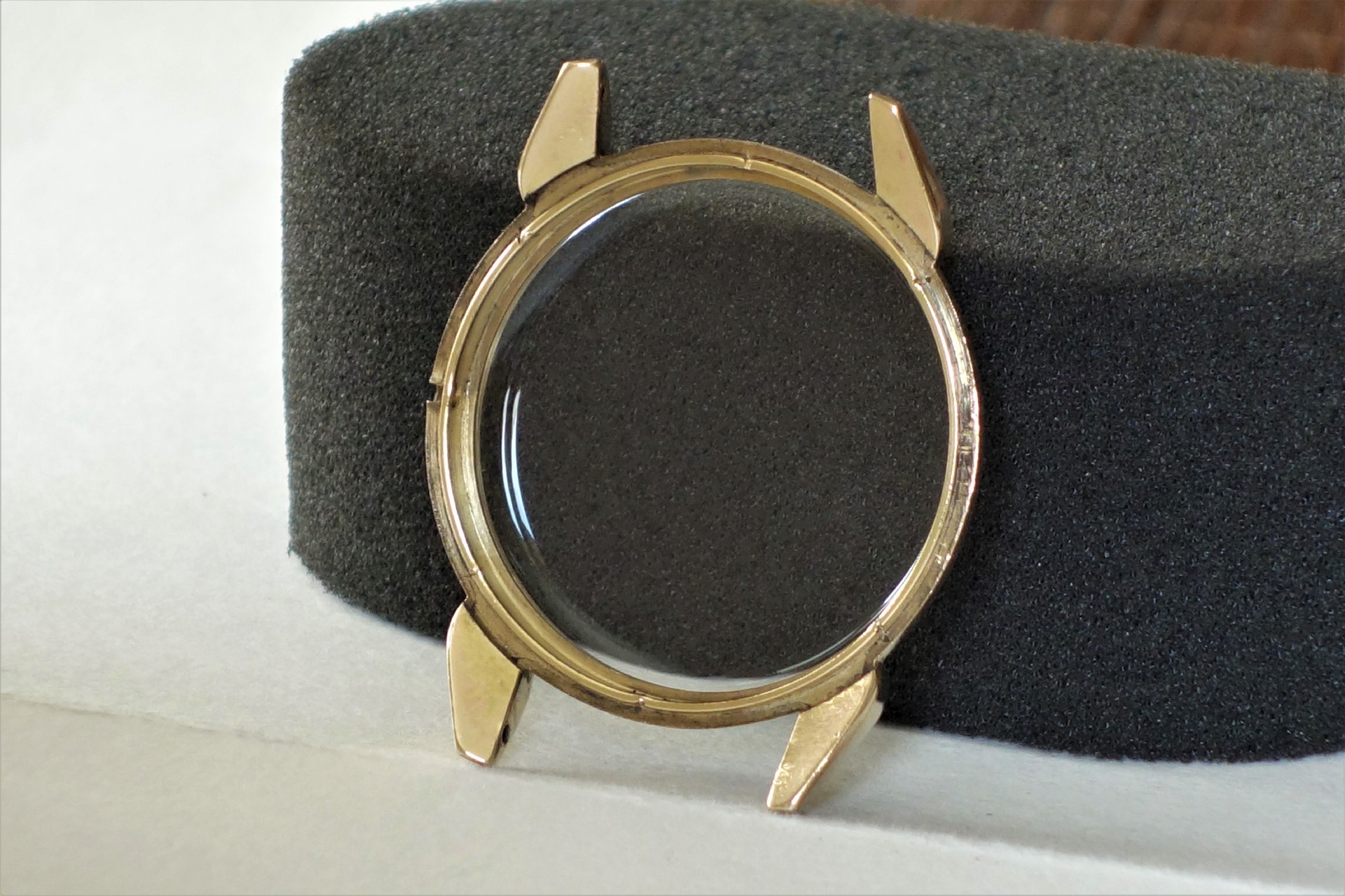 Rundes Uhrgehäuse in goldfarbener Optik mit transparentem Uhrglas.