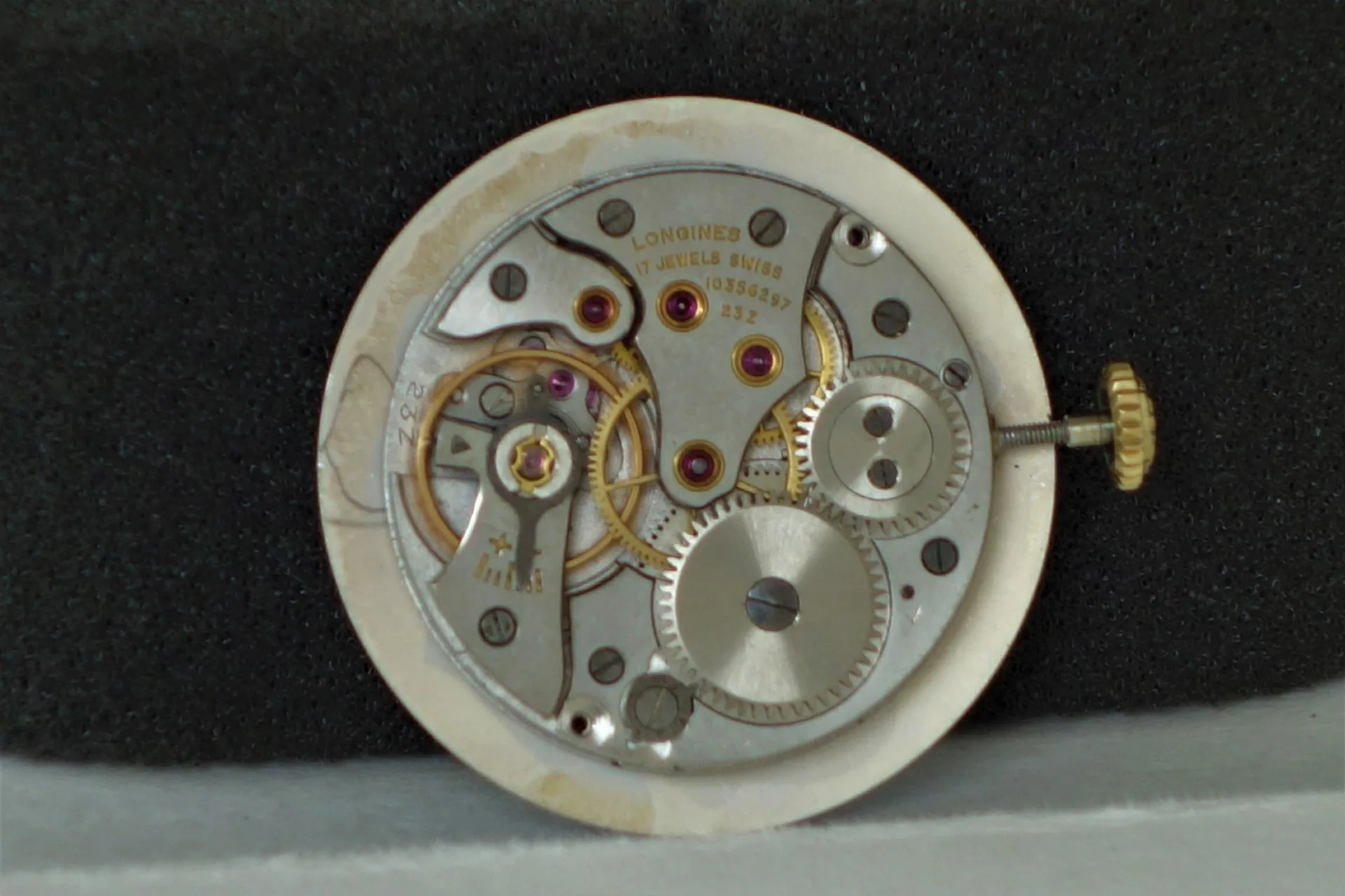 Uhrwerk Longines mechanisch Mechanisches Uhrwerk von Longines mit sichtbaren Zahnrädern und goldfarbener Krone.