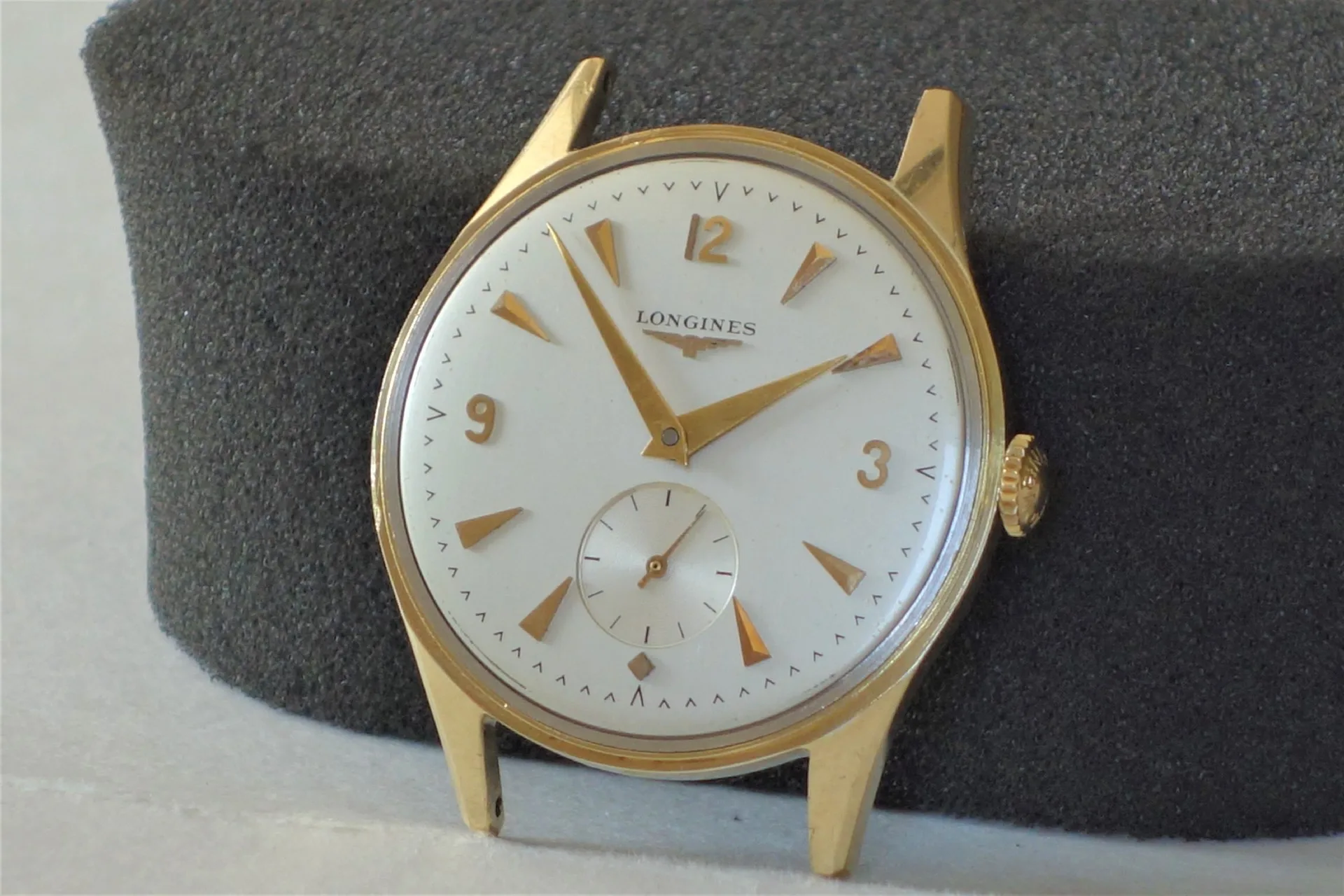 Longines Armbanduhr goldfarben Runde Armbanduhr mit weißem Zifferblatt und goldfarbenem Gehäuse sowie goldfarbenen Zeigern und Indizes.