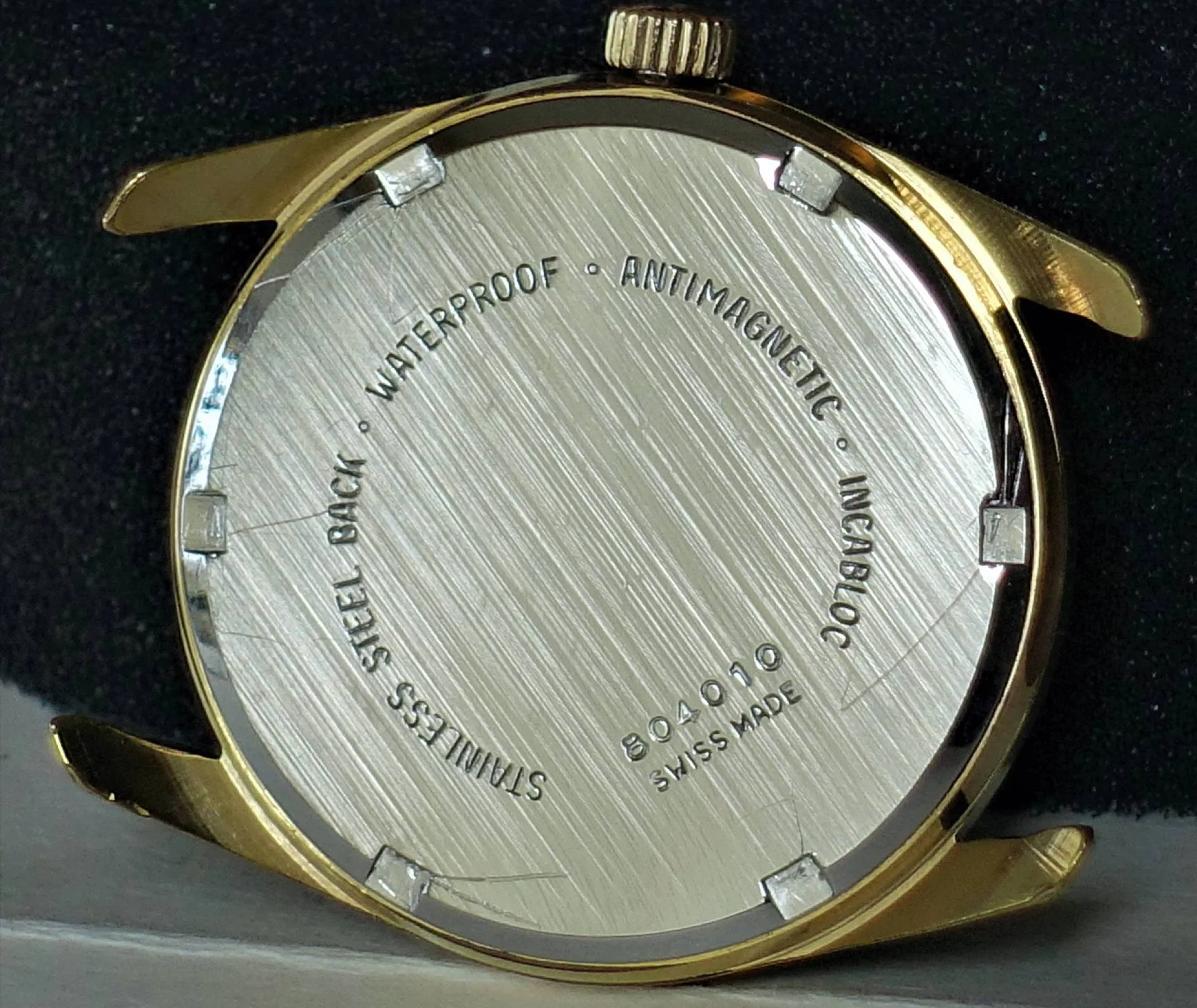 Gehäuse goldfarben mit Boden Goldfarbenes Uhrgehäuse mit silberner Rückseite und verschraubtem Boden.
