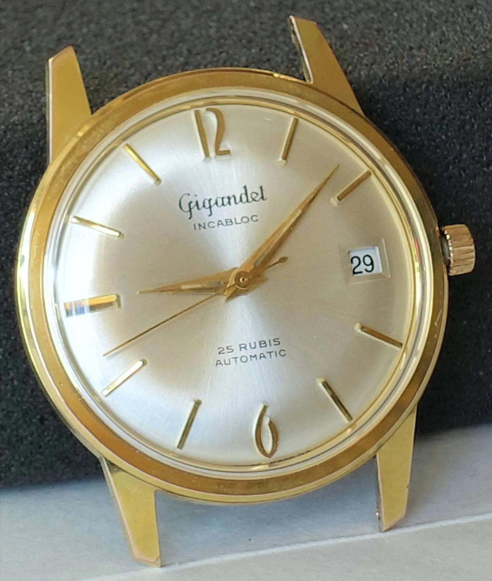 Goldfarbenes Vintage-Uhrgehäuse silbernes Zifferblatt Eine klassische Armbanduhr mit goldfarbenem Gehäuse, silbernem Zifferblatt, goldfarbenen Zeigern und Indizes sowie Datumsanzeige bei drei Uhr.