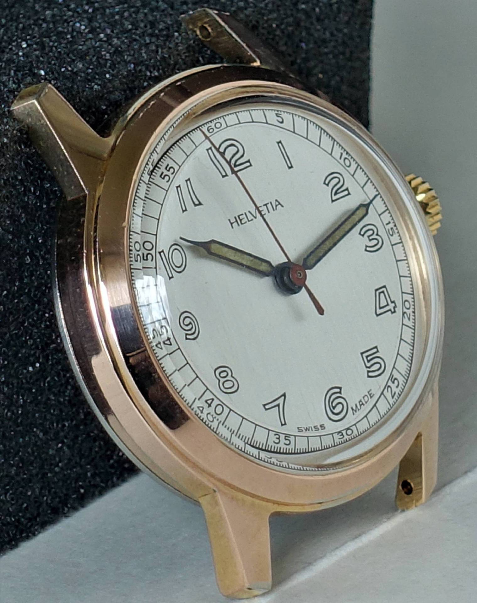 Goldfarbene Armbanduhr mit weißem Zifferblatt und schwarzen Zahlen, Marke Helvetia.