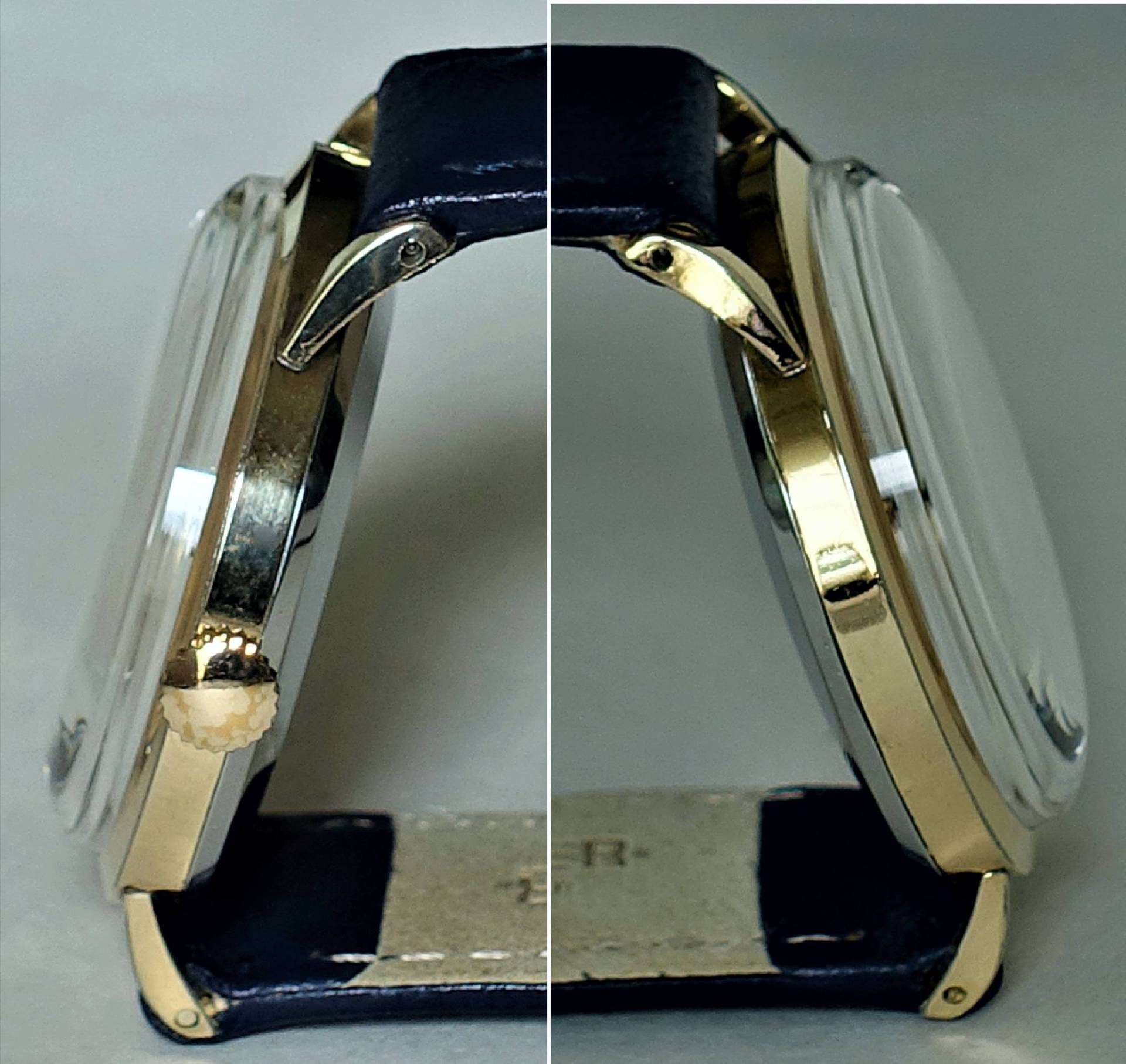 Flache Armbanduhr mit goldfarbenem Gehäuse und dunklem Armband in seitlicher Ansicht.