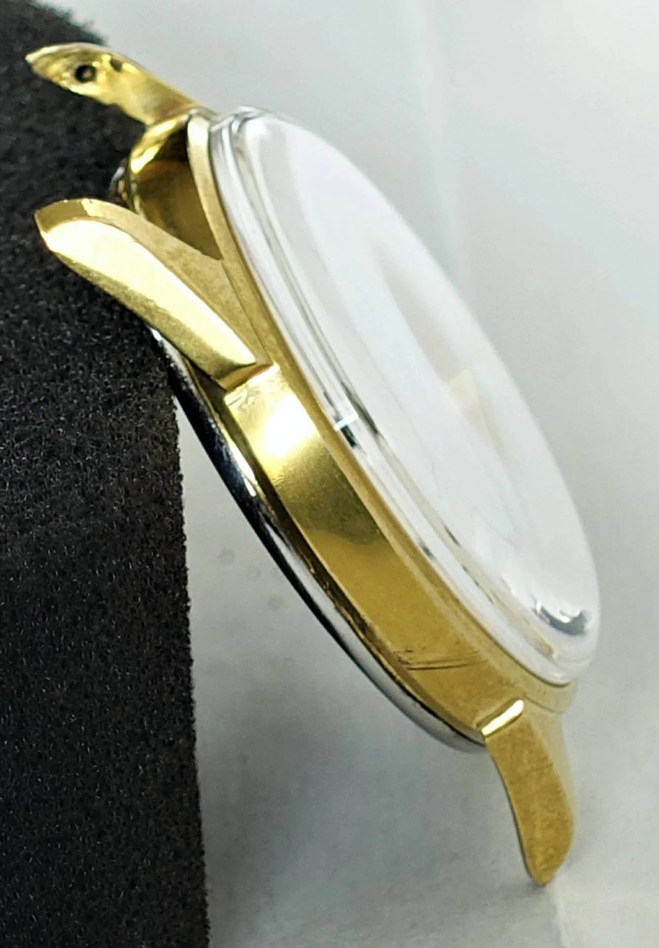 Goldfarbenes Uhrengehäuse mit montiertem Uhrglas.