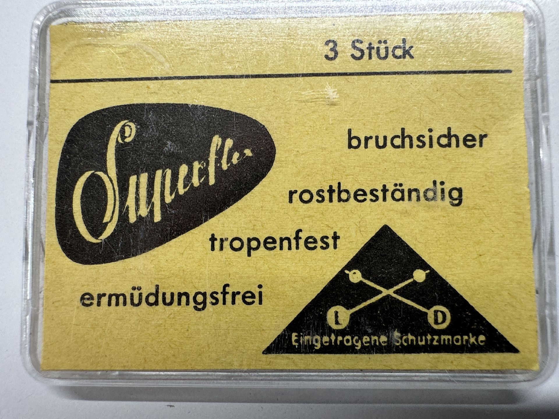 Gelbe Verpackung mit drei bruchsicheren und rostbeständigen Federstegen für Uhren.