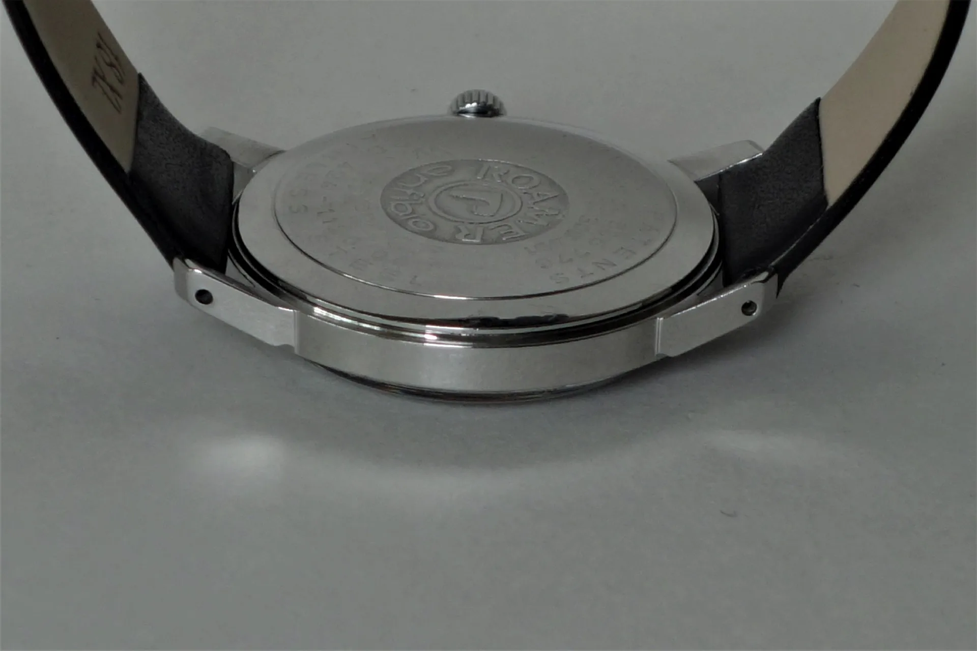 Uhrboden silberfarben Runder silberfarbener Uhrenboden mit Gravur an einer Armbanduhr.