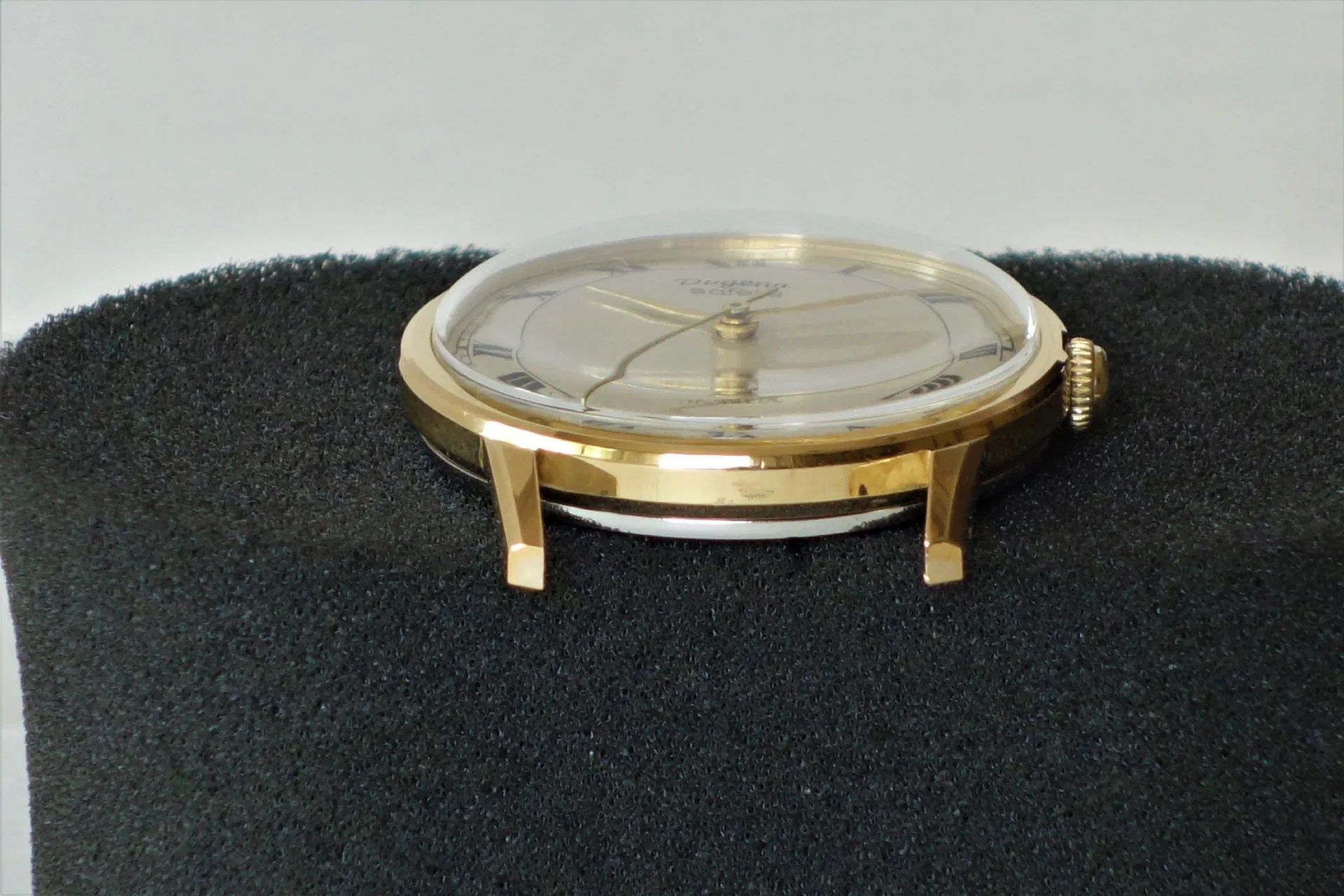 Rundes Uhrgehäuse in goldfarbener Optik mit montiertem Zifferblatt und Zeigern.