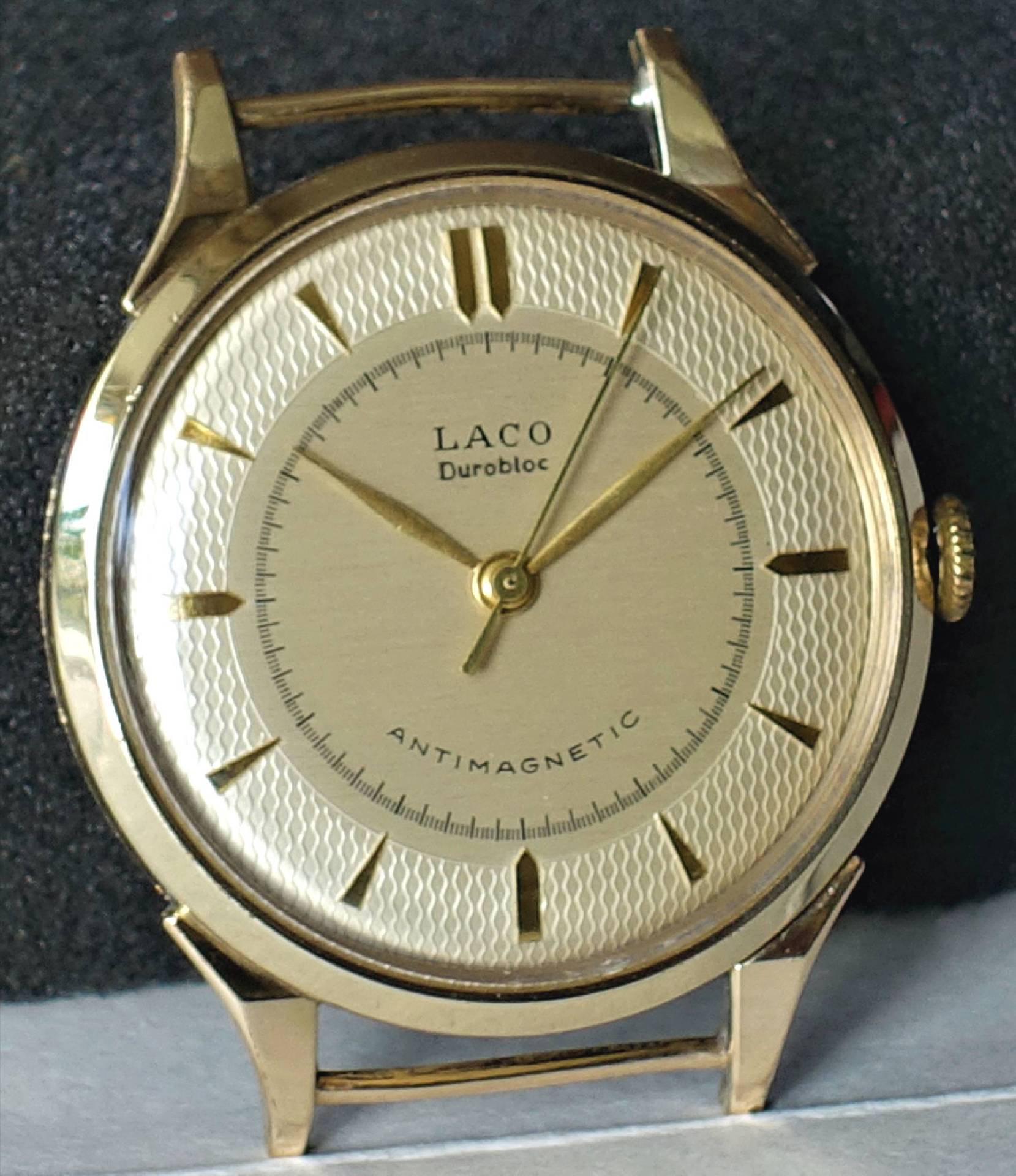 Goldfarbene analoge Armbanduhr mit hellem Zifferblatt und goldenen Indizes.