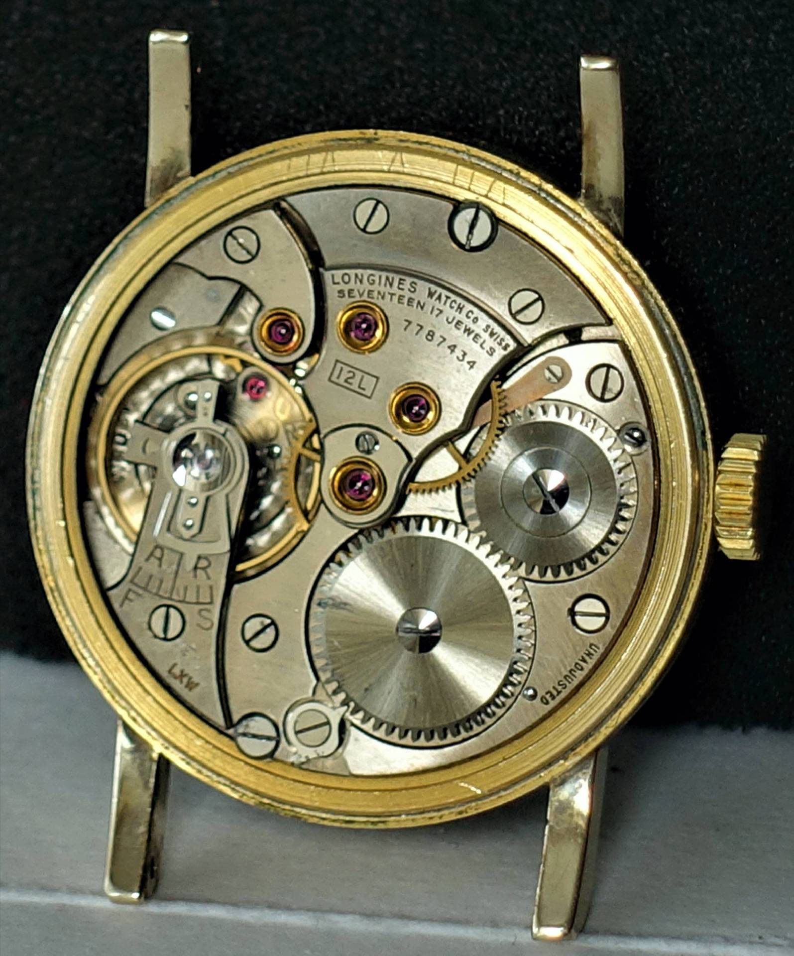 Detailaufnahme des mechanischen Uhrwerks einer Longines Uhr, zeigt 17 Rubinen und präzise Zahnräder.