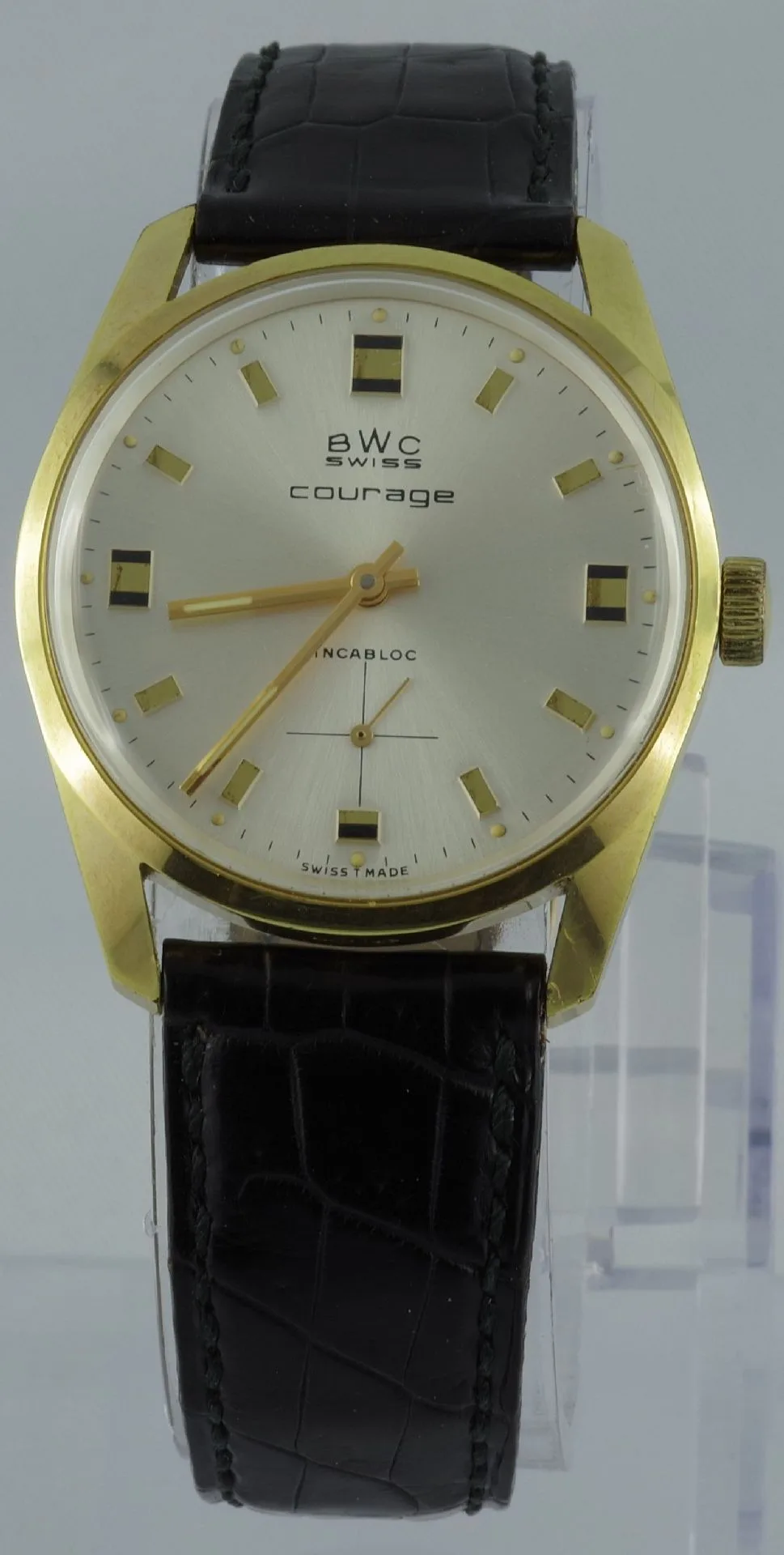 BWC Swiss Armbanduhr gold Analoge Armbanduhr mit goldfarbenem Gehäuse, silbernem Zifferblatt und schwarzem Lederarmband.