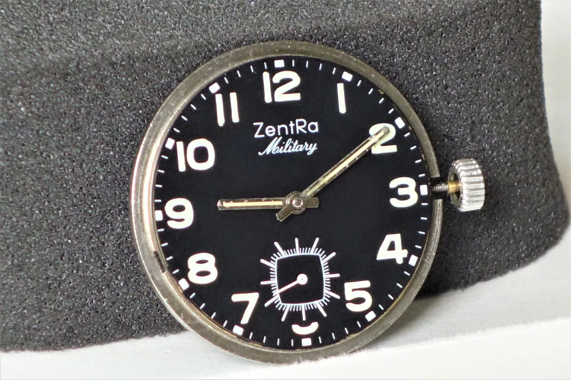 ZentRa Military Uhrwerk Schwarzes Uhrwerk mit weißer ZentRa Military Beschriftung und silberner Krone.