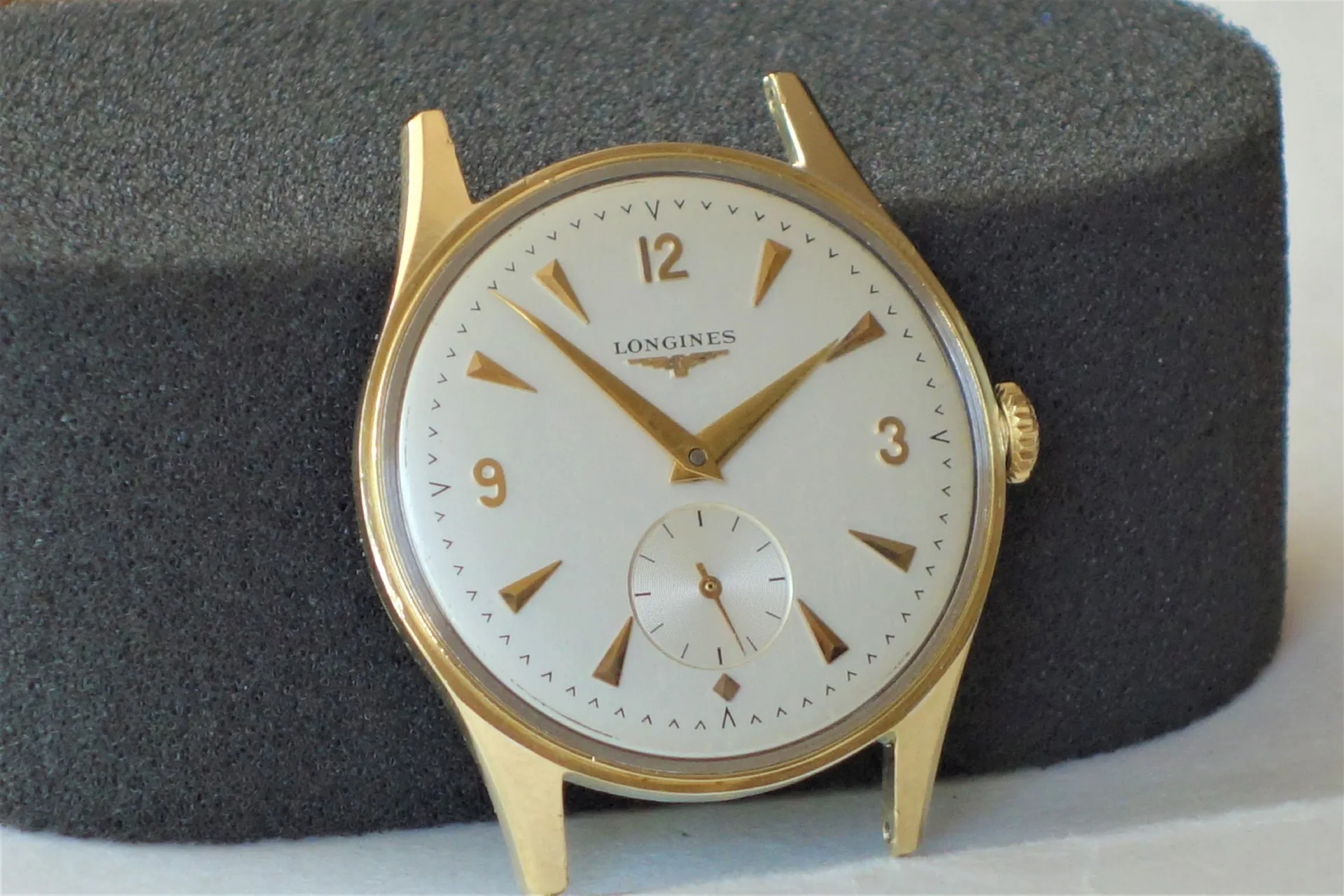 Analoguhr Gehäuse goldfarben Rundes Uhrgehäuse mit weißem Zifferblatt und goldfarbenen Zeigern und Indizes.