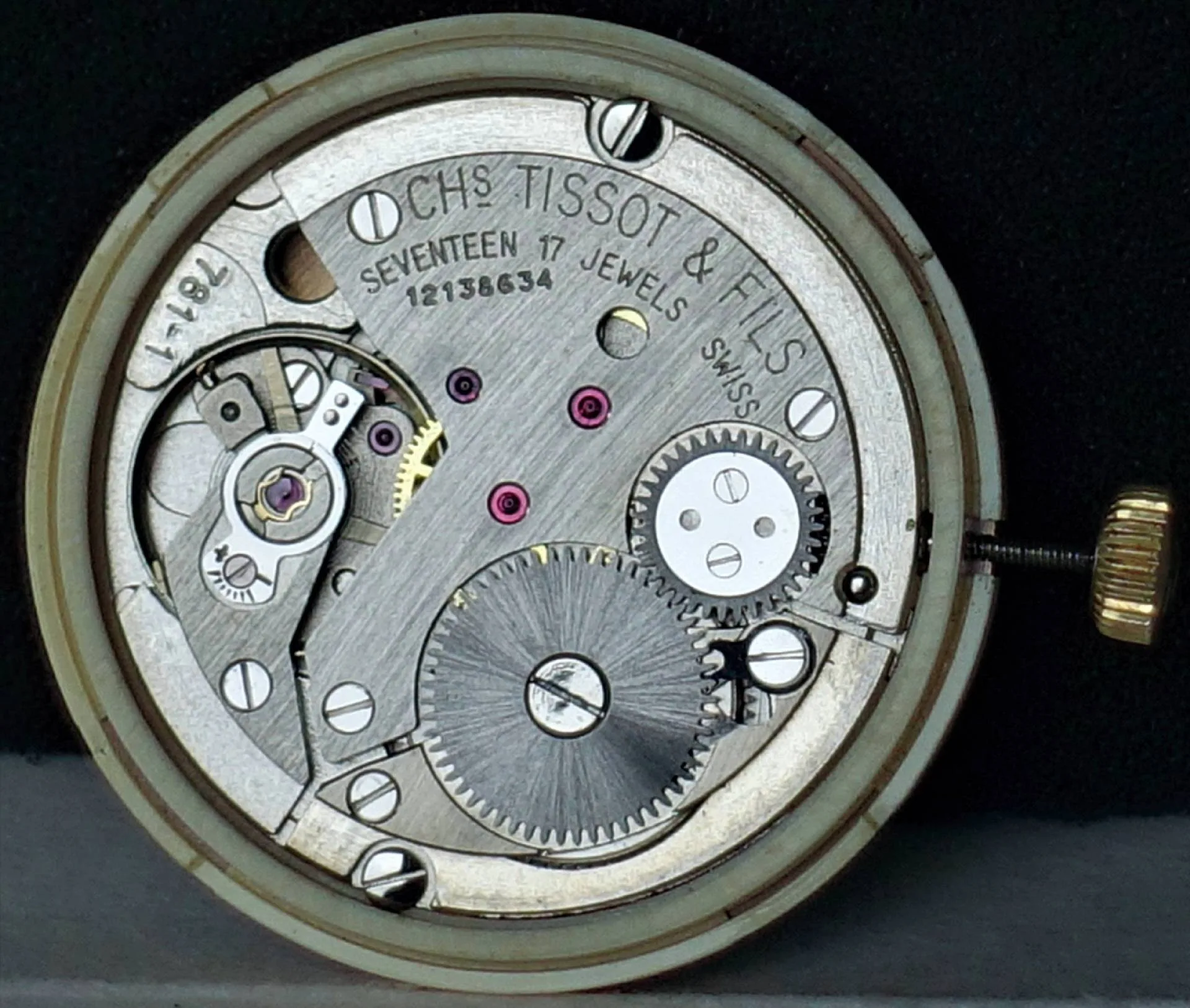 Mechanisches Uhrwerk silberfarben Silberfarbenes mechanisches Uhrwerk mit sichtbaren Zahnrädern und goldfarbener Krone.