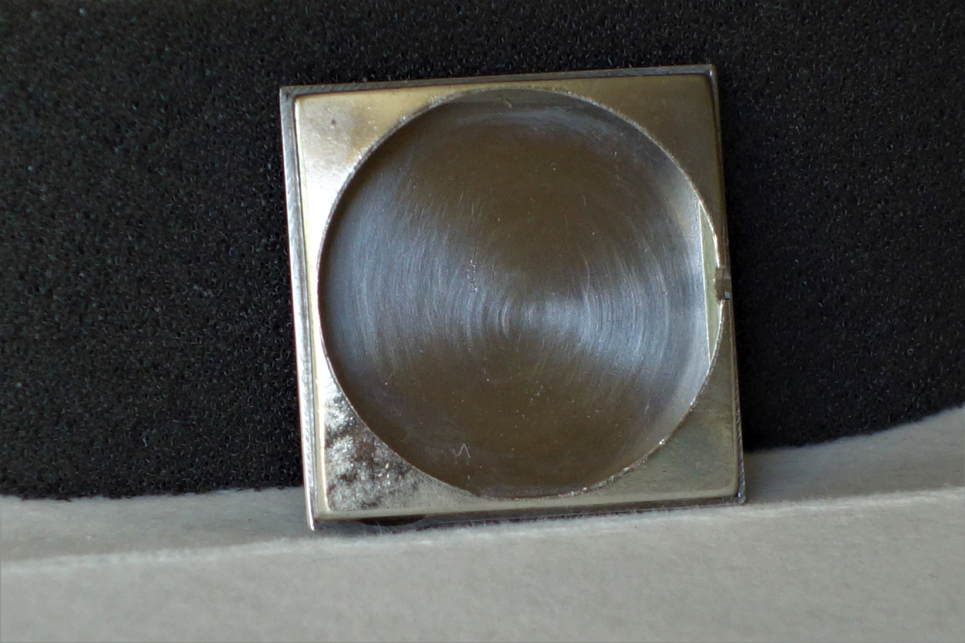Quadratischer Gehäuseboden aus Metall für Armbanduhren.
