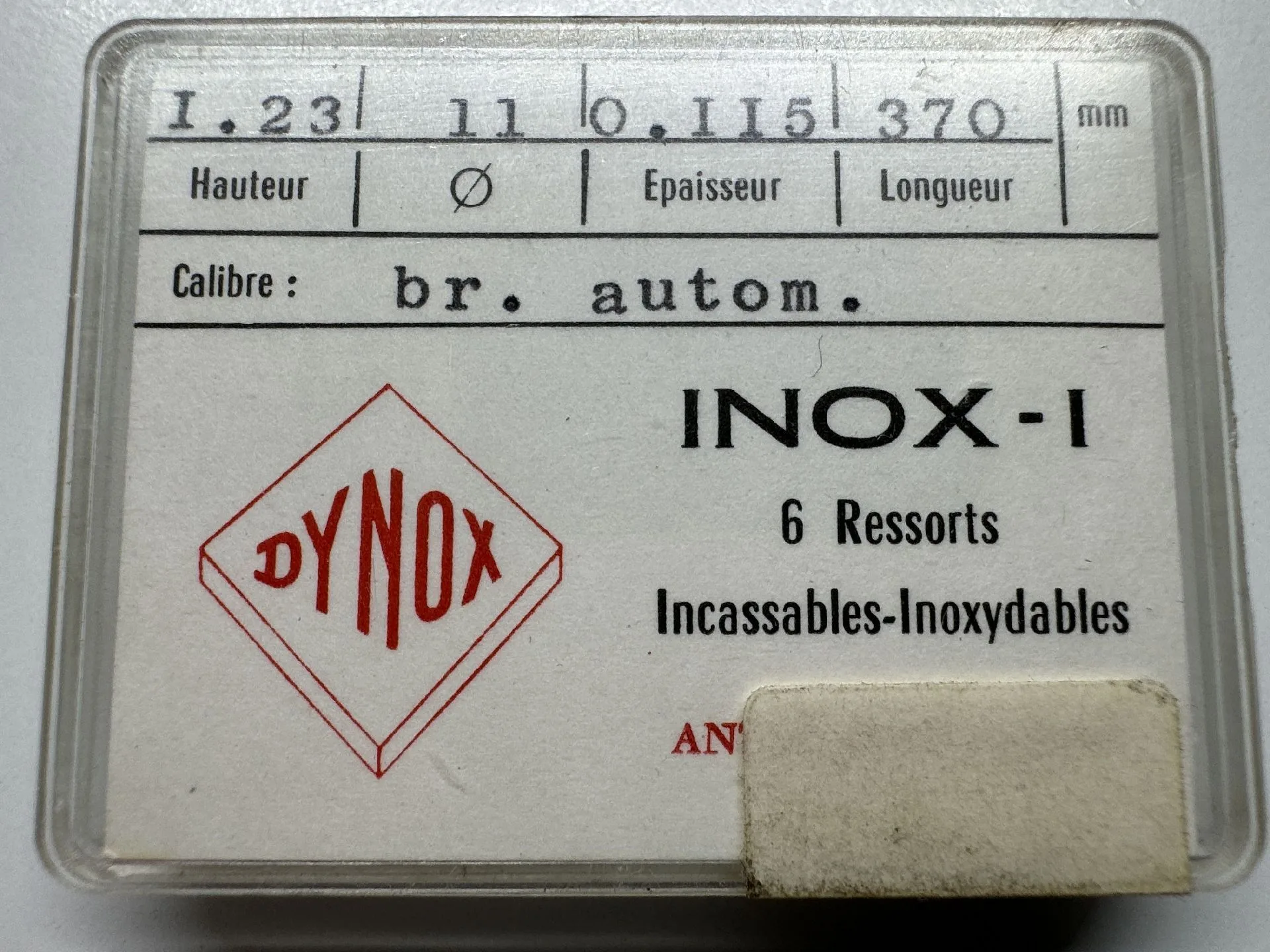 Dynox INOX-1 Uhrfedern Verpackung mit sechs silberfarbenen Uhrfedern für Automatikuhren, beschriftet mit Dynox INOX-1.