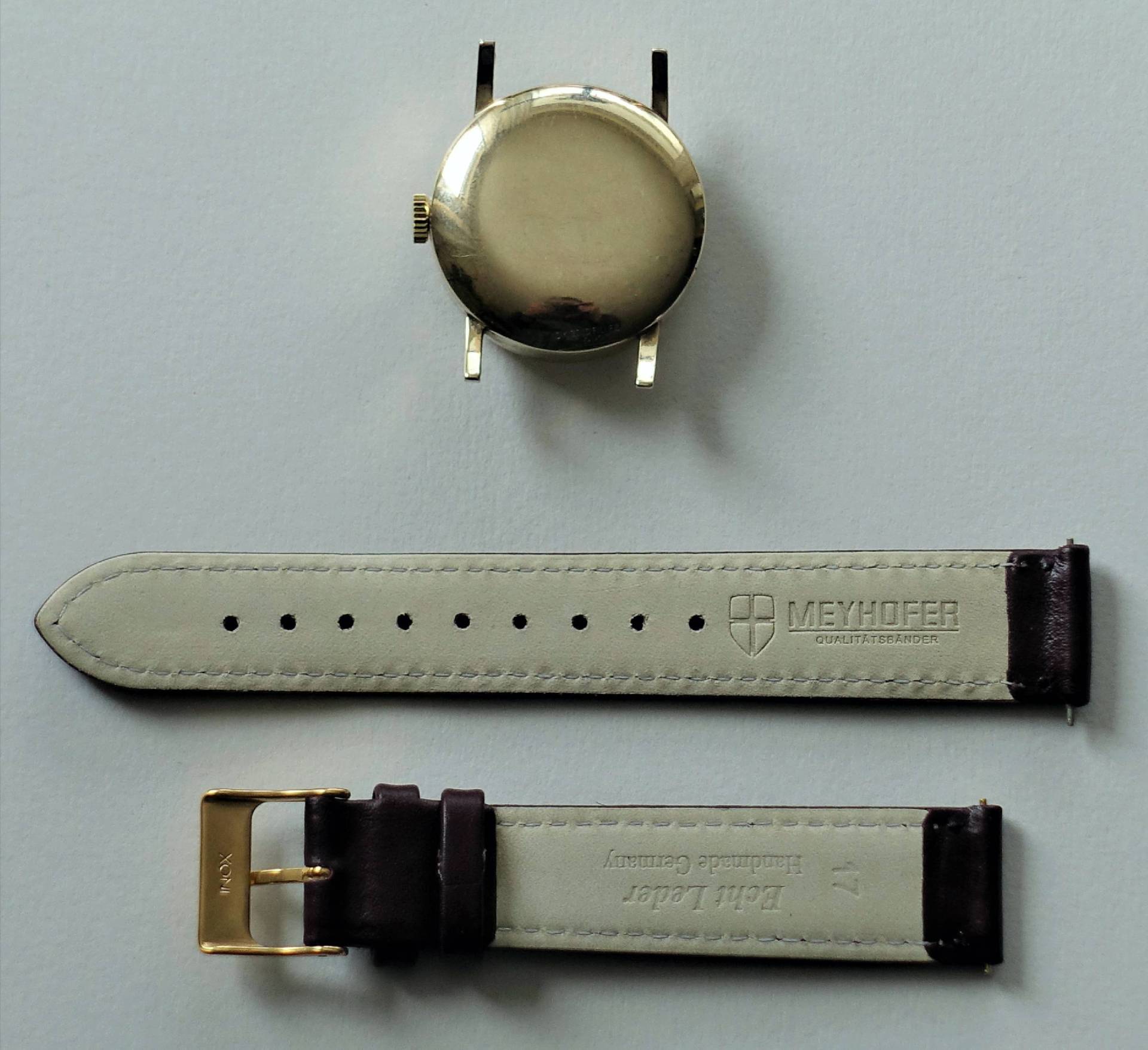 Uhrengehäuse von Meyhofer und passendes Lederarmband auf weißem Hintergrund