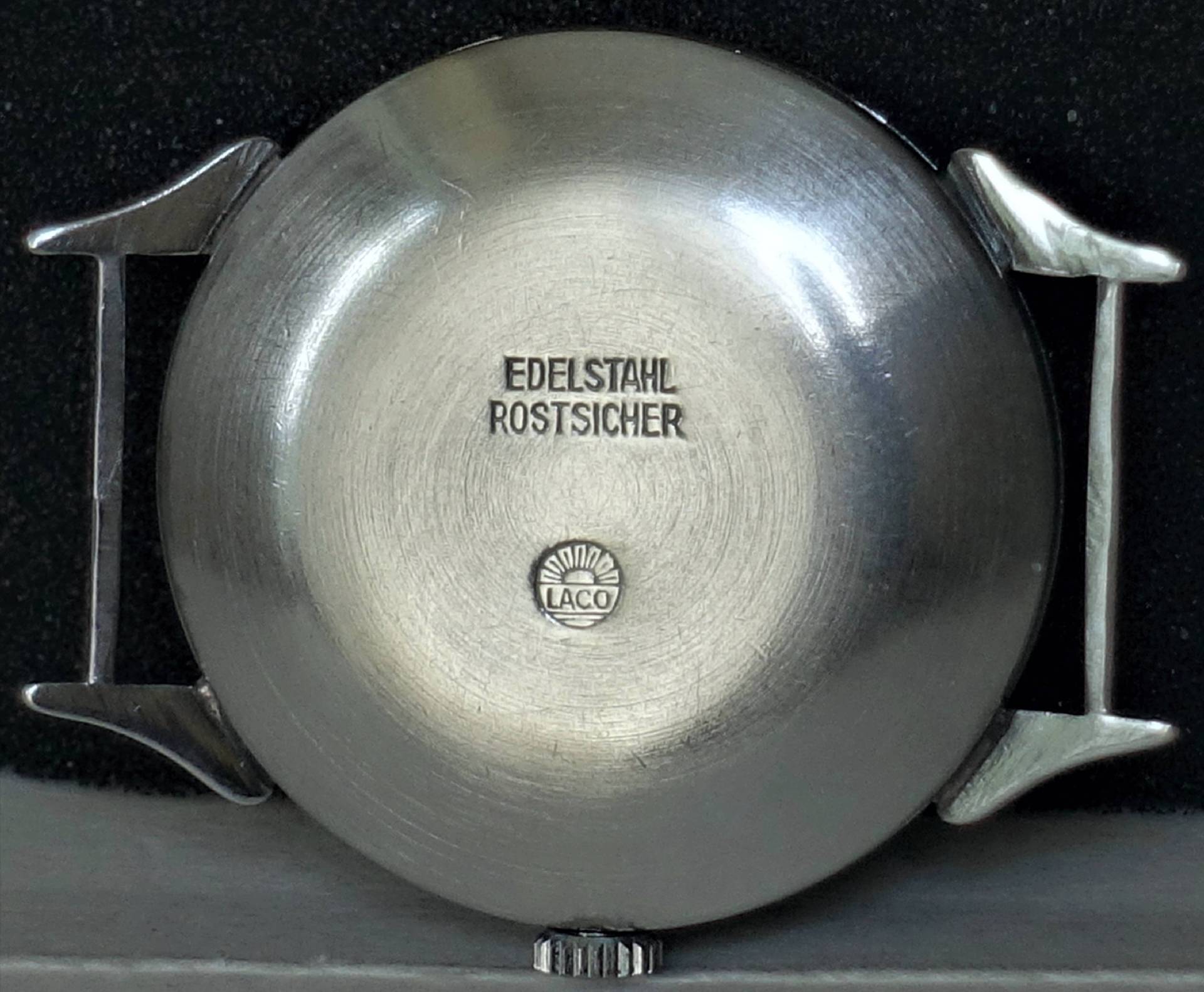 Silberfarbenes Edelstahlgehäuse einer Armbanduhr mit Laco-Logo und Gravur "Edelstahl Rostsicher".