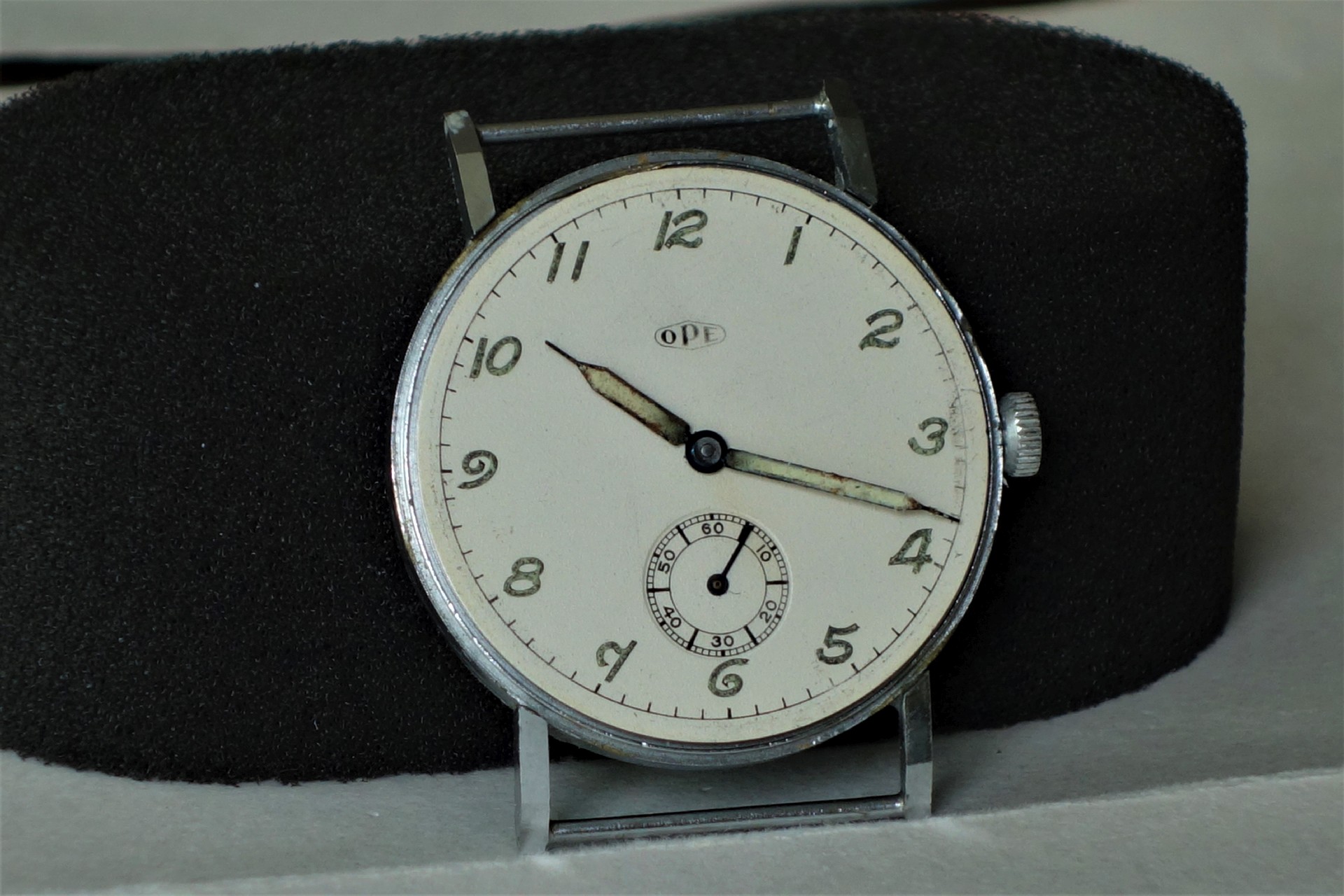 Runde Armbanduhr mit silberfarbenem Gehäuse, weißem Zifferblatt und schwarzen arabischen Zahlen.