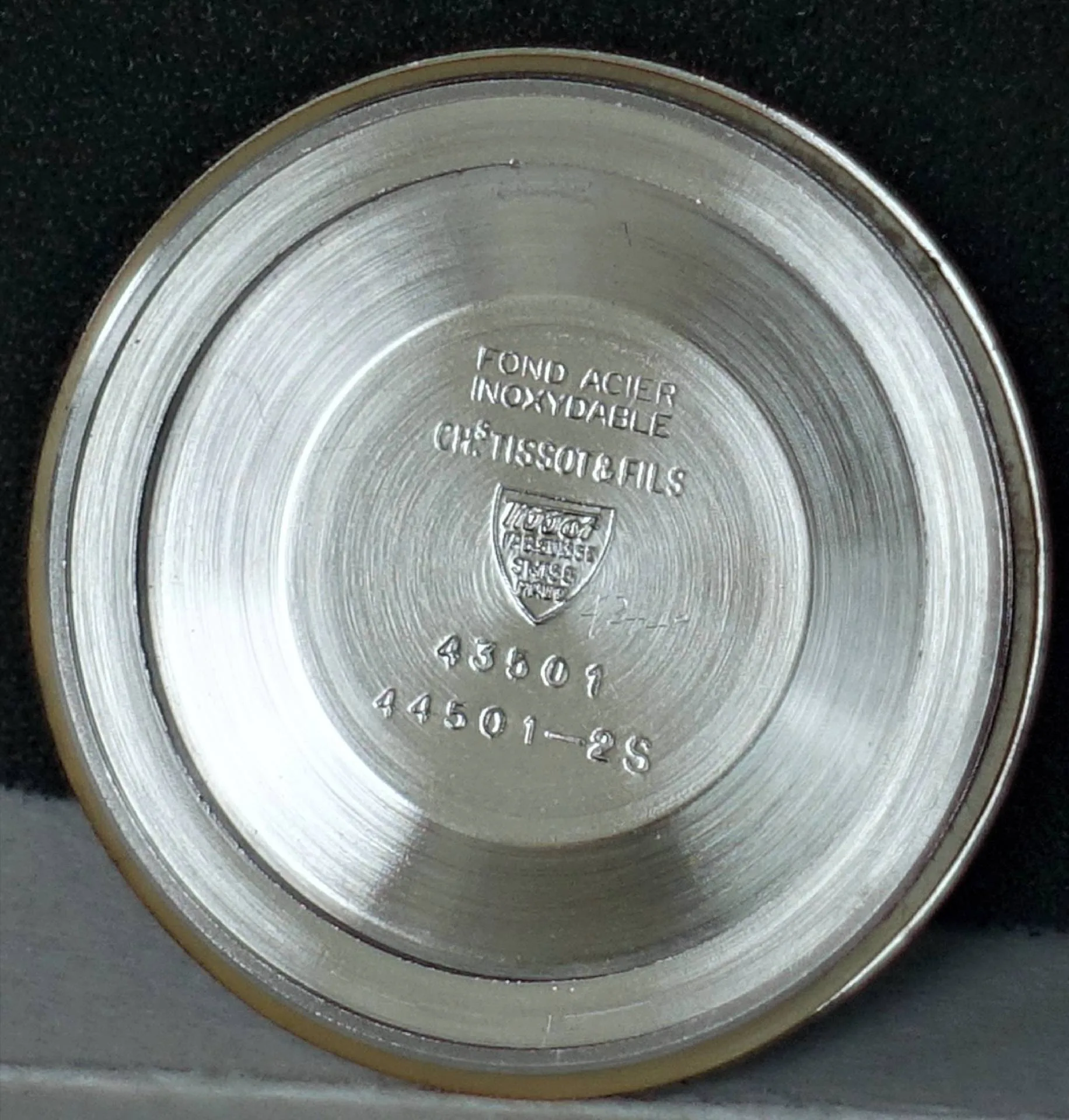 Silberfarbener Gehäuseboden aus Metall mit Prägung und Gravur für Armbanduhren.