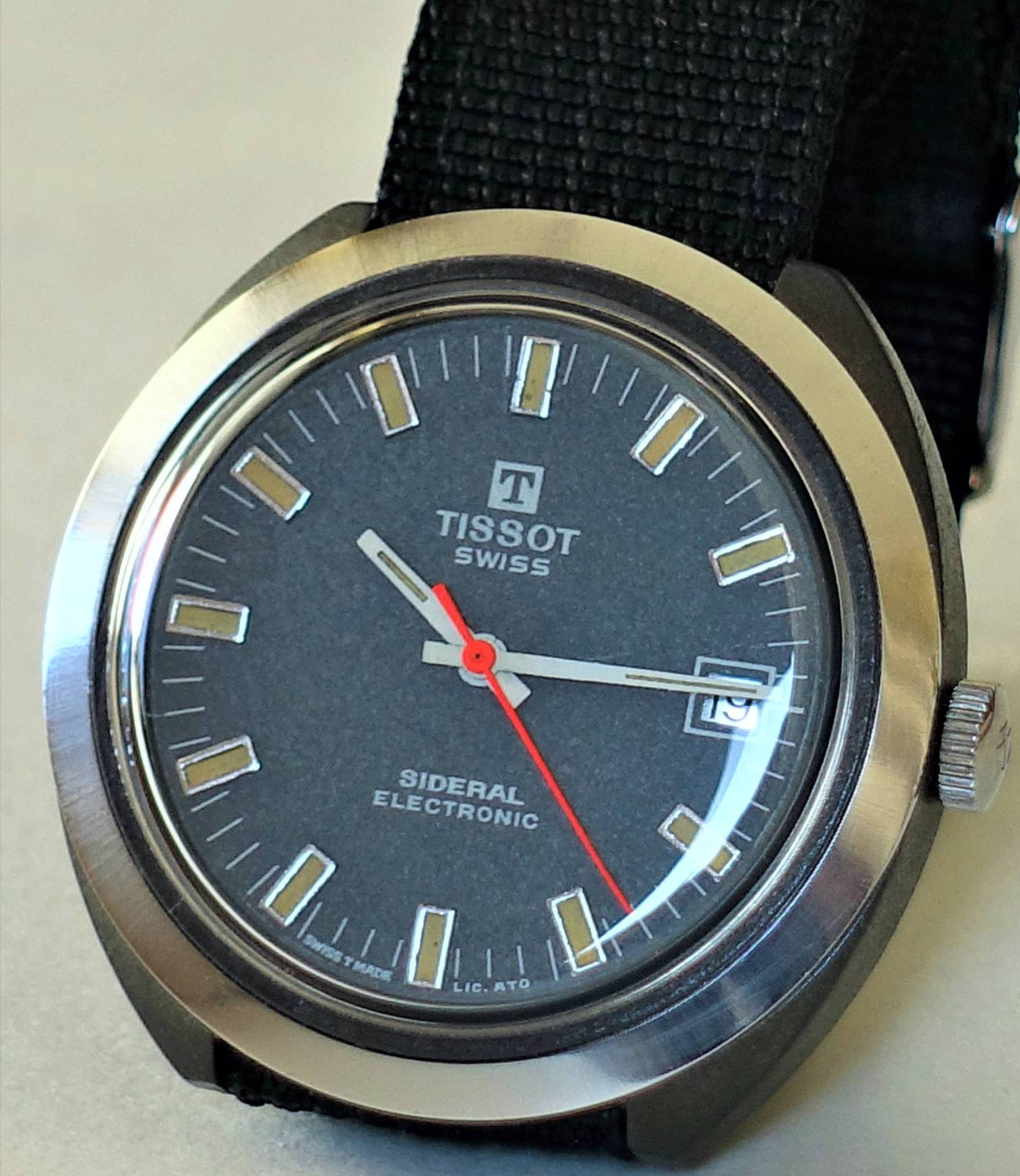 Nahaufnahme einer Tissot Sideral Uhr mit grauem Zifferblatt und rotem Sekundenzeiger