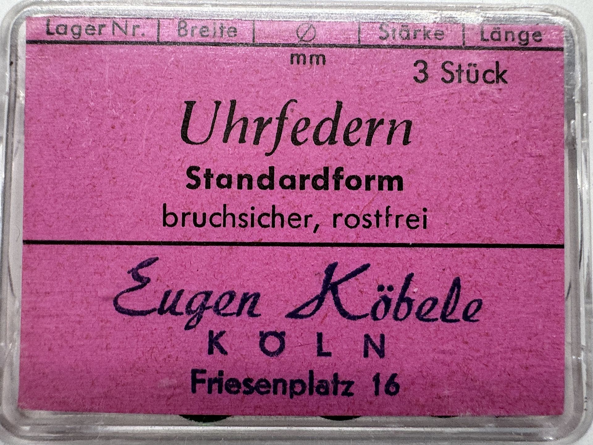 Drei bruchsichere und rostfreie Uhrfedern in einer transparenten Verpackung mit violettem Etikett.