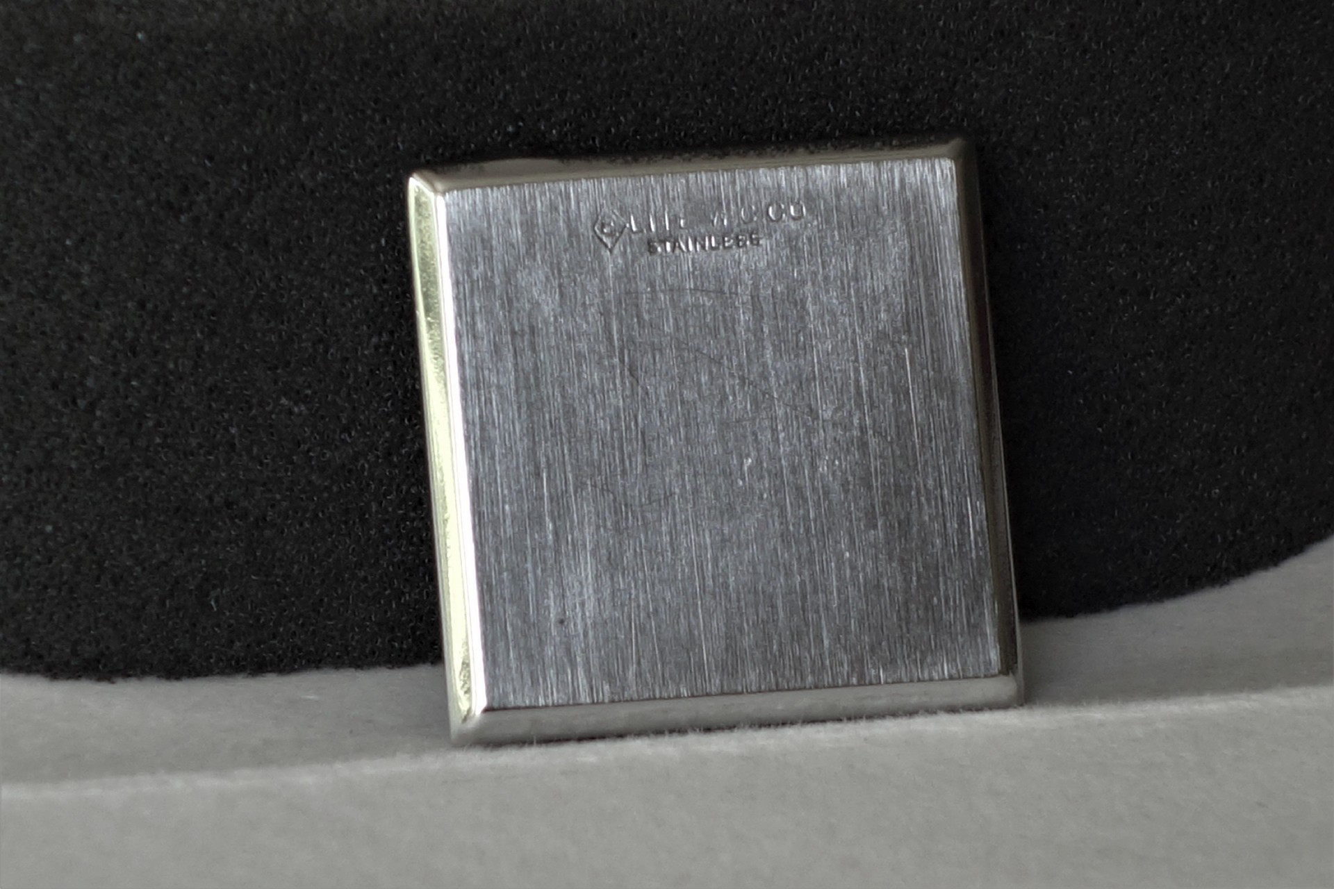 Quadratischer Gehäuseboden aus gebürstetem Edelstahl für Armbanduhren.