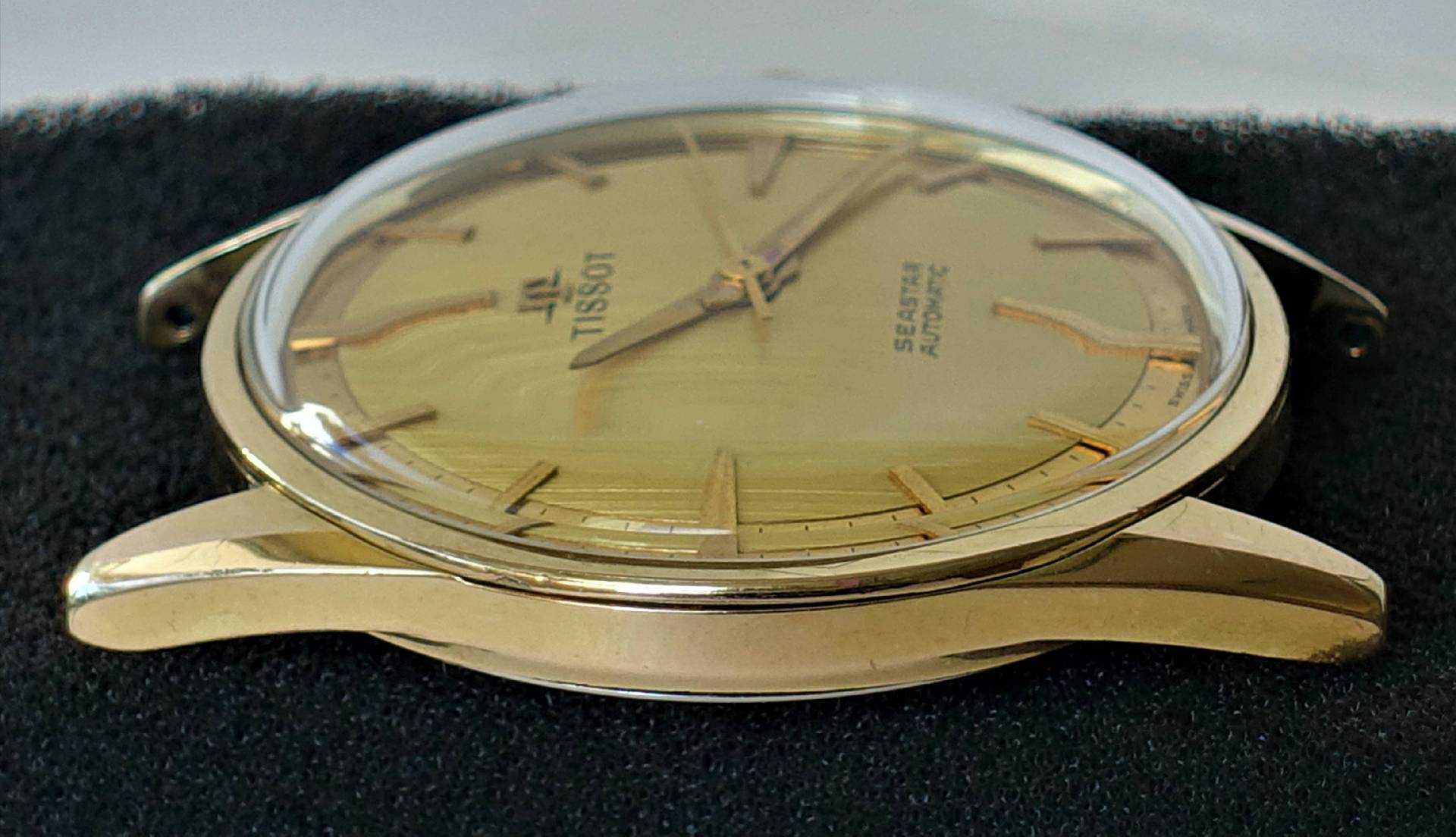 Goldfarbene Tissot Armbanduhr mit Automatikwerk und goldfarbenem Zifferblatt.