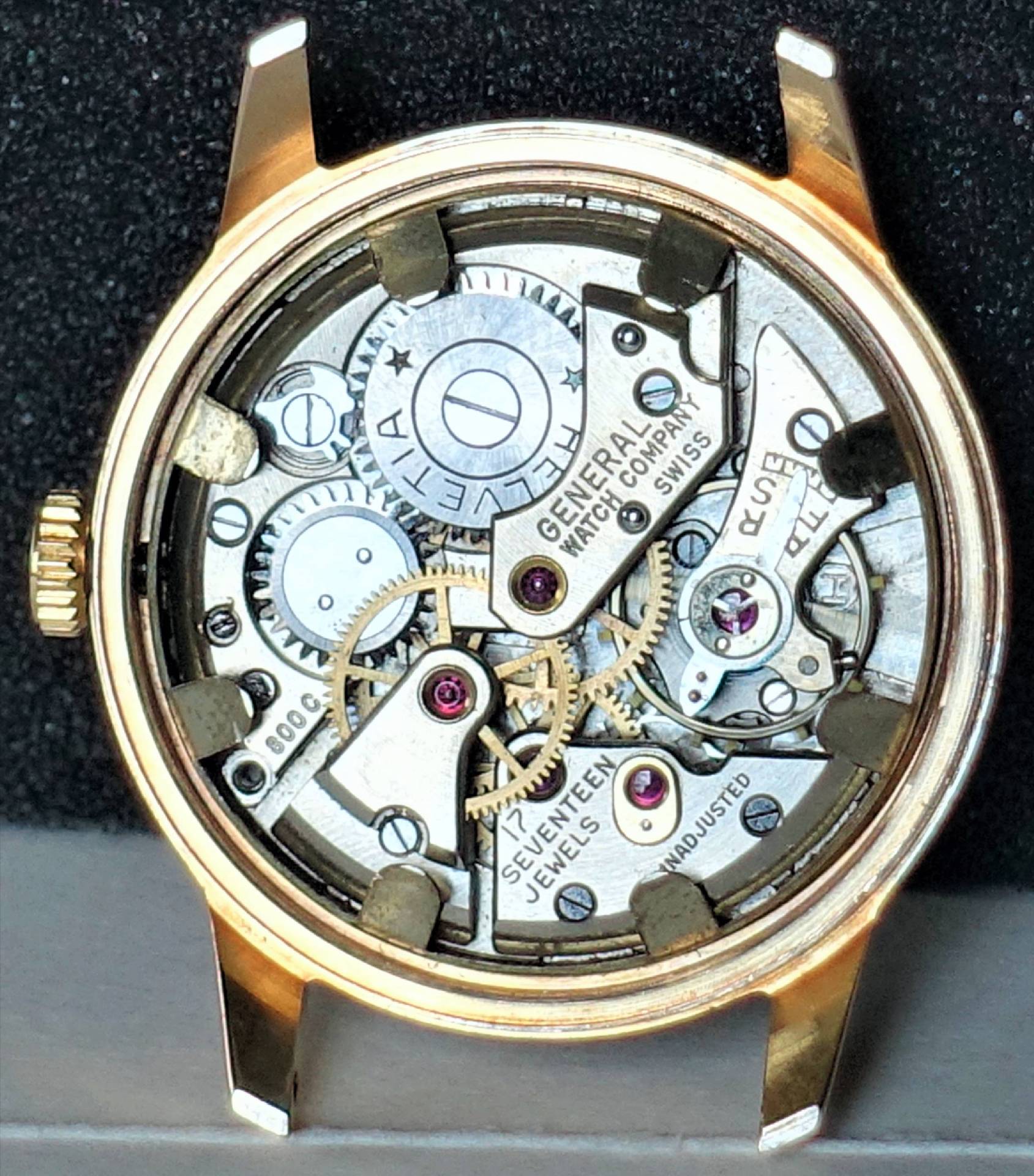 Mechanisches Uhrwerk der General Watch Company in einem goldfarbenen Gehäuse.